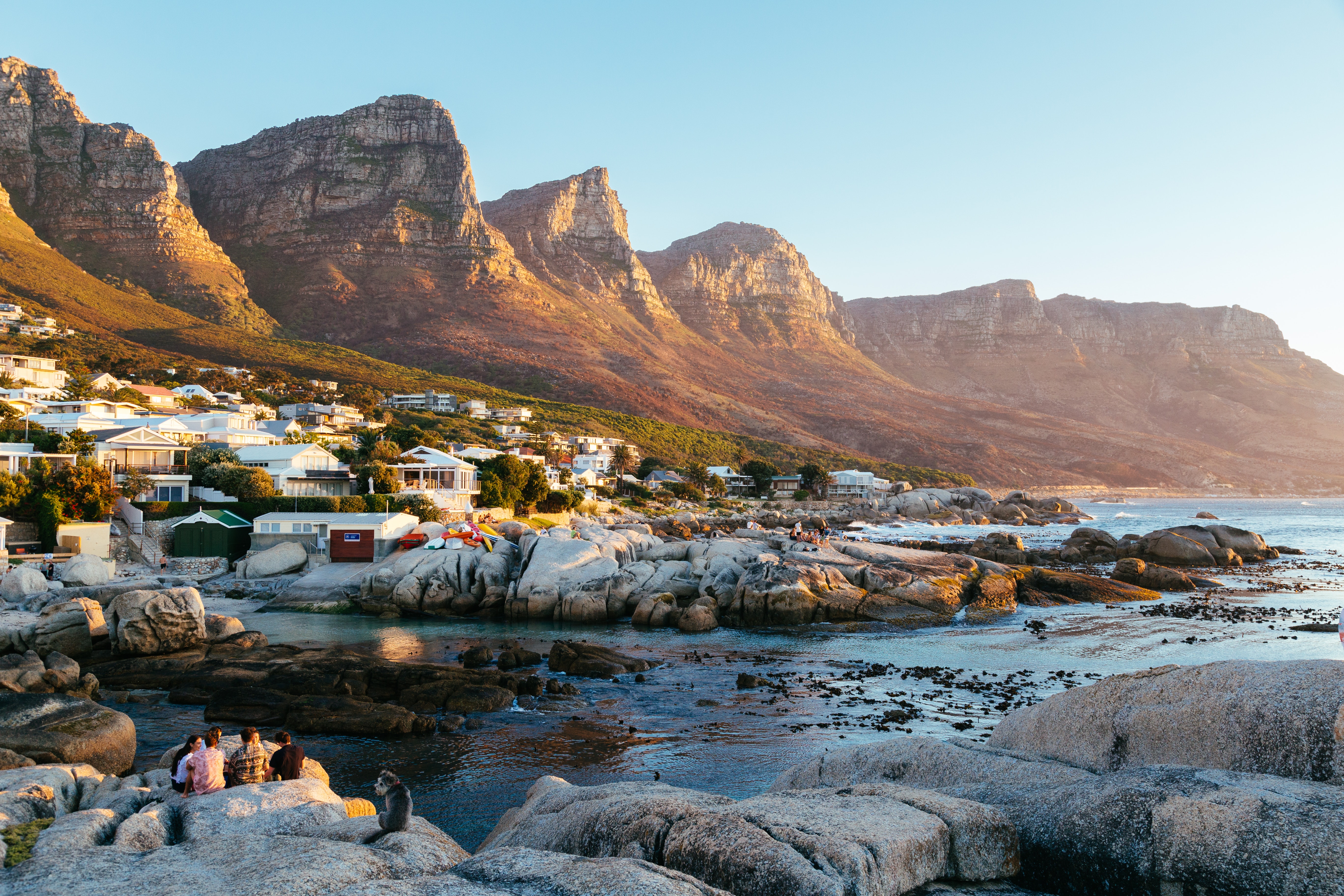 Coastal town with mountains at sunset HD Wallpaper