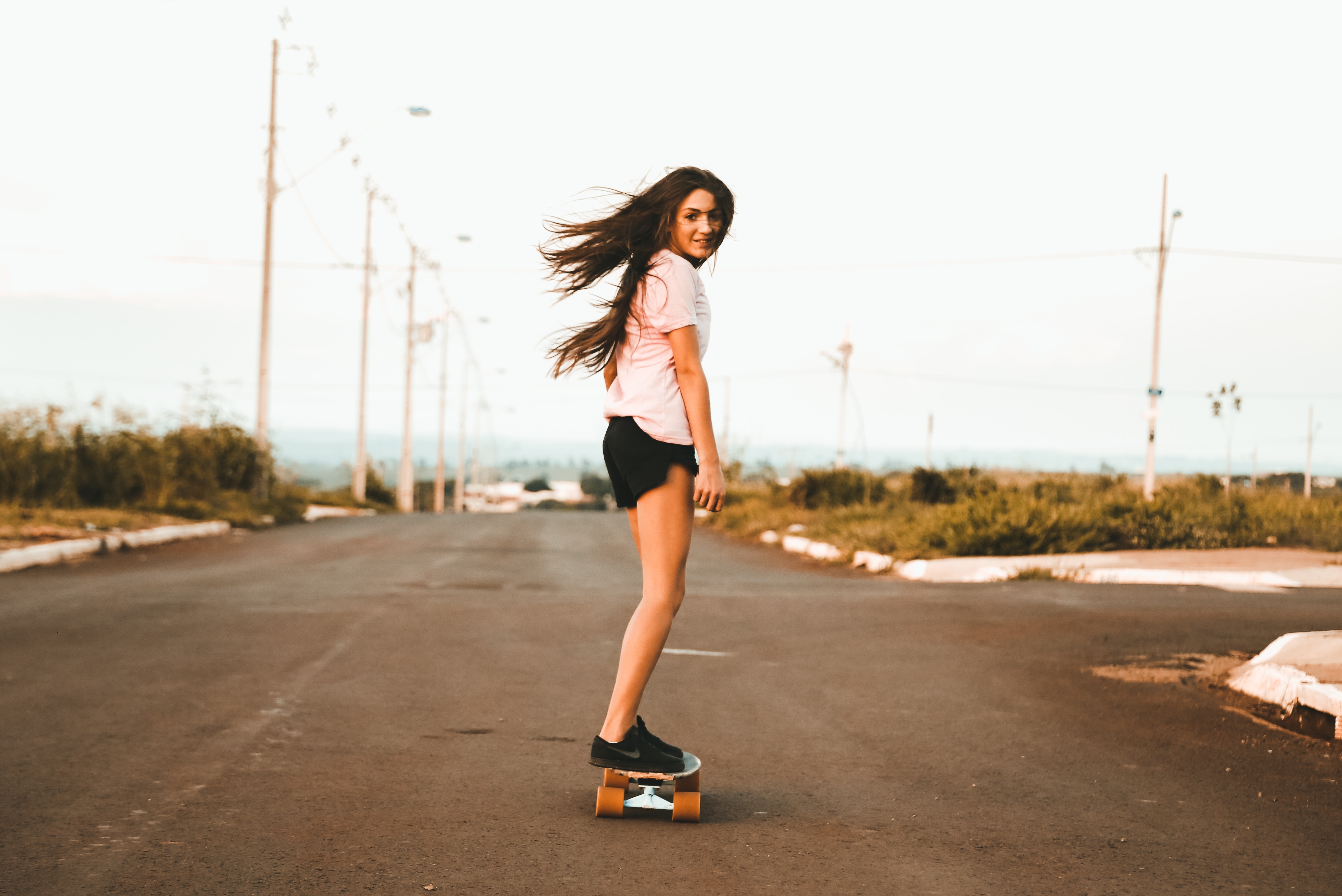 Girl Skateboarding on Empty Road at Sunset 4K HD Wallpaper
