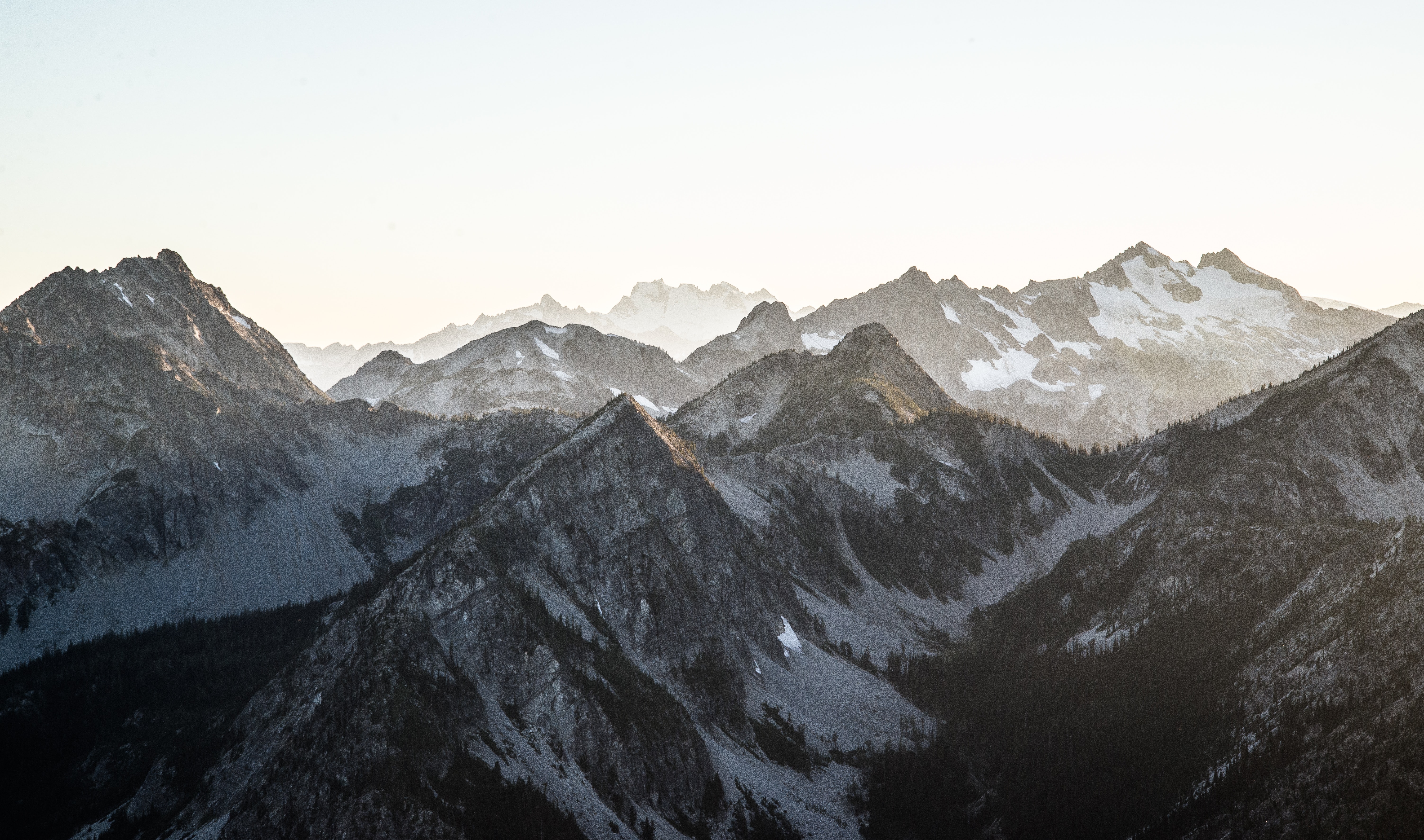 Snow-capped mountains under a bright sky HD Wallpaper