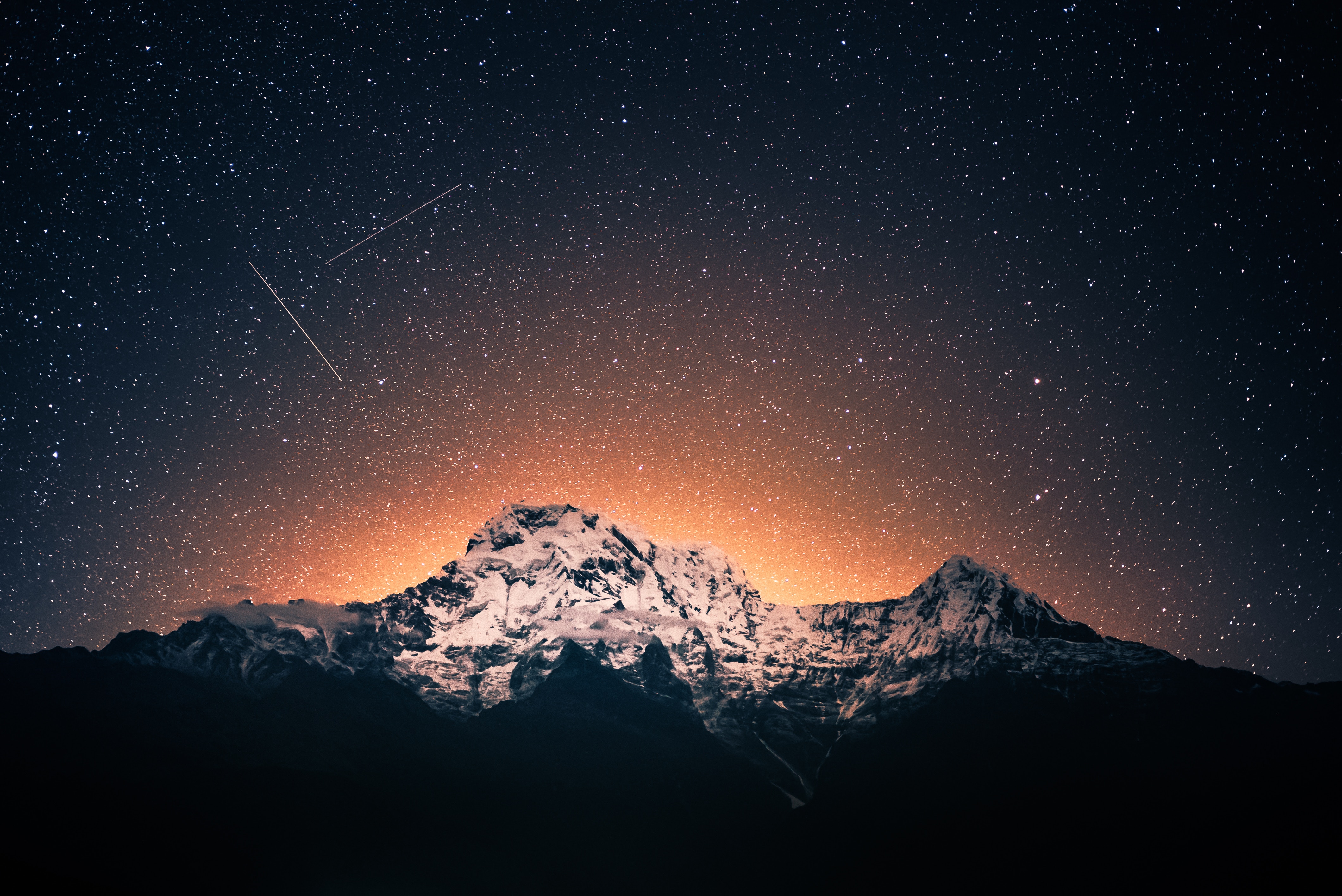 Snow-capped mountains under a starry sky with shooting stars HD Wallpaper