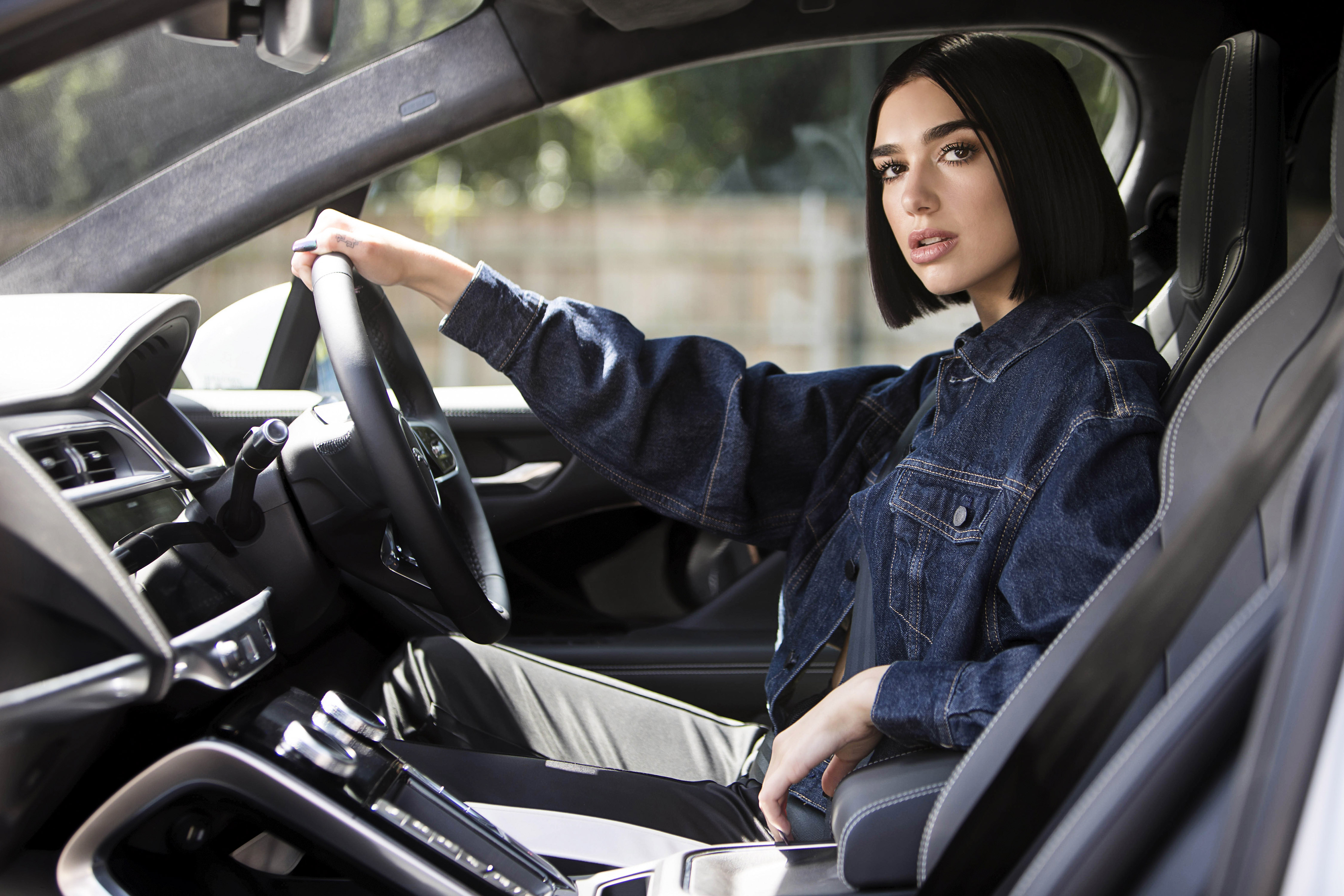Dua Lipa in a denim jacket driving a car HD Wallpaper