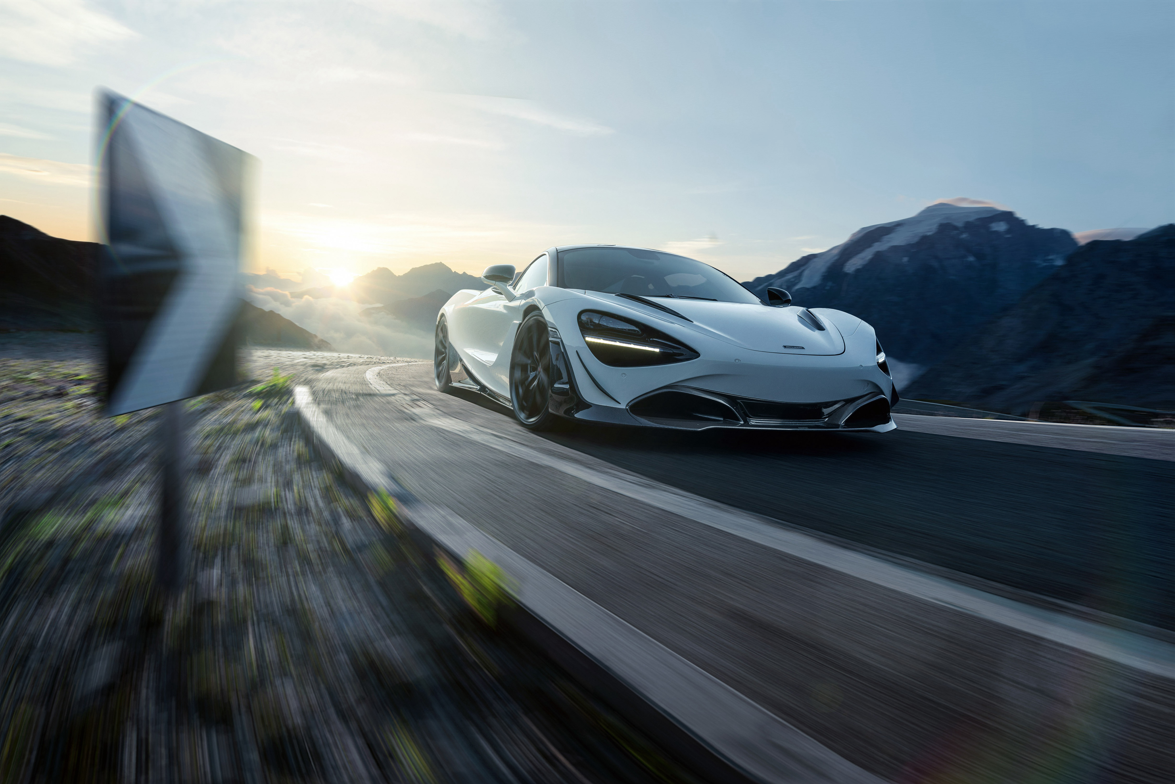 White McLaren 720S driving on a mountain road at sunset HD Wallpaper