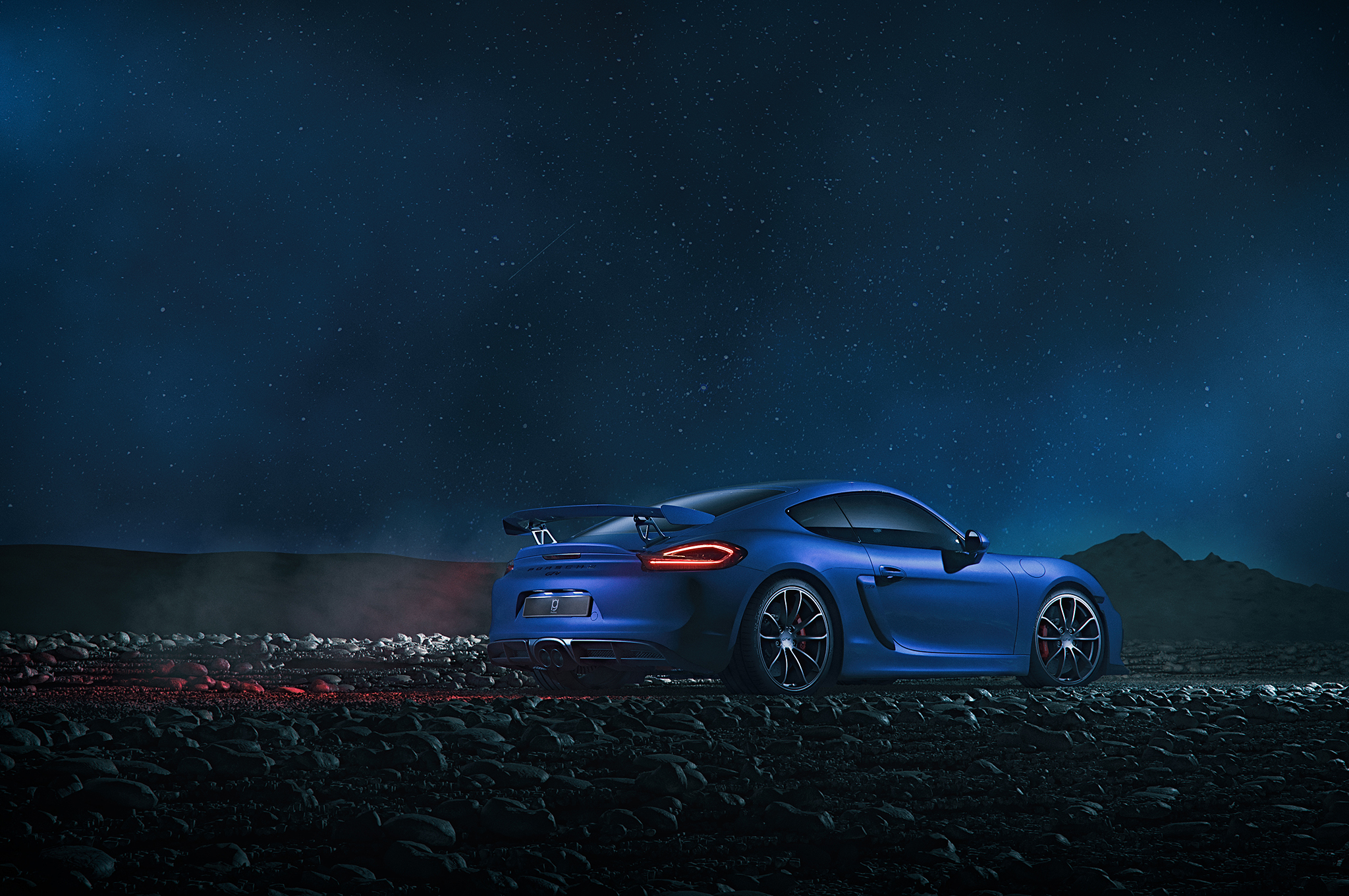 Blue Porsche Cayman GT4 on rocky terrain at night HD Wallpaper