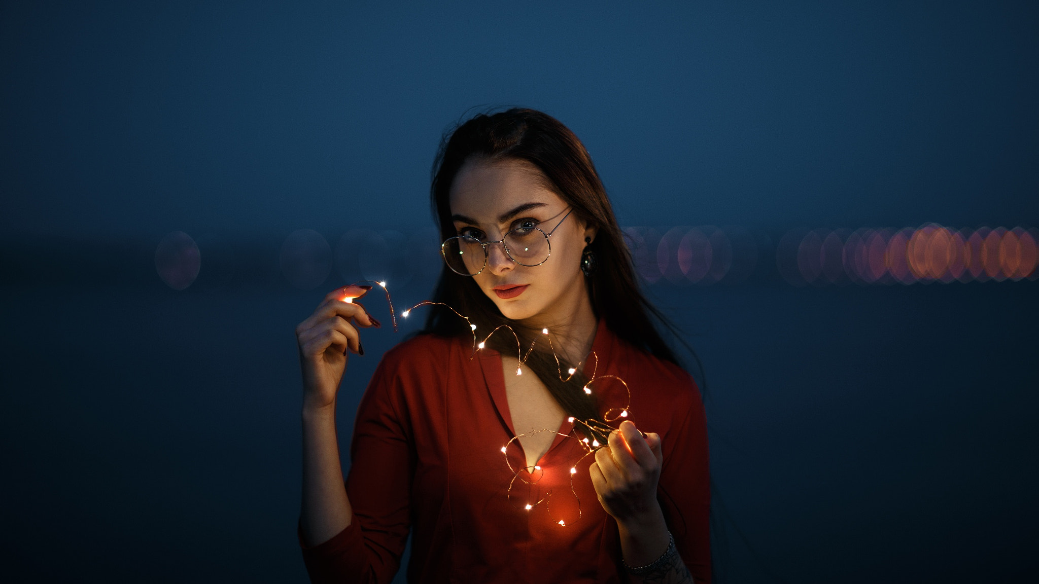 Woman with glasses holding fairy lights HD Wallpaper