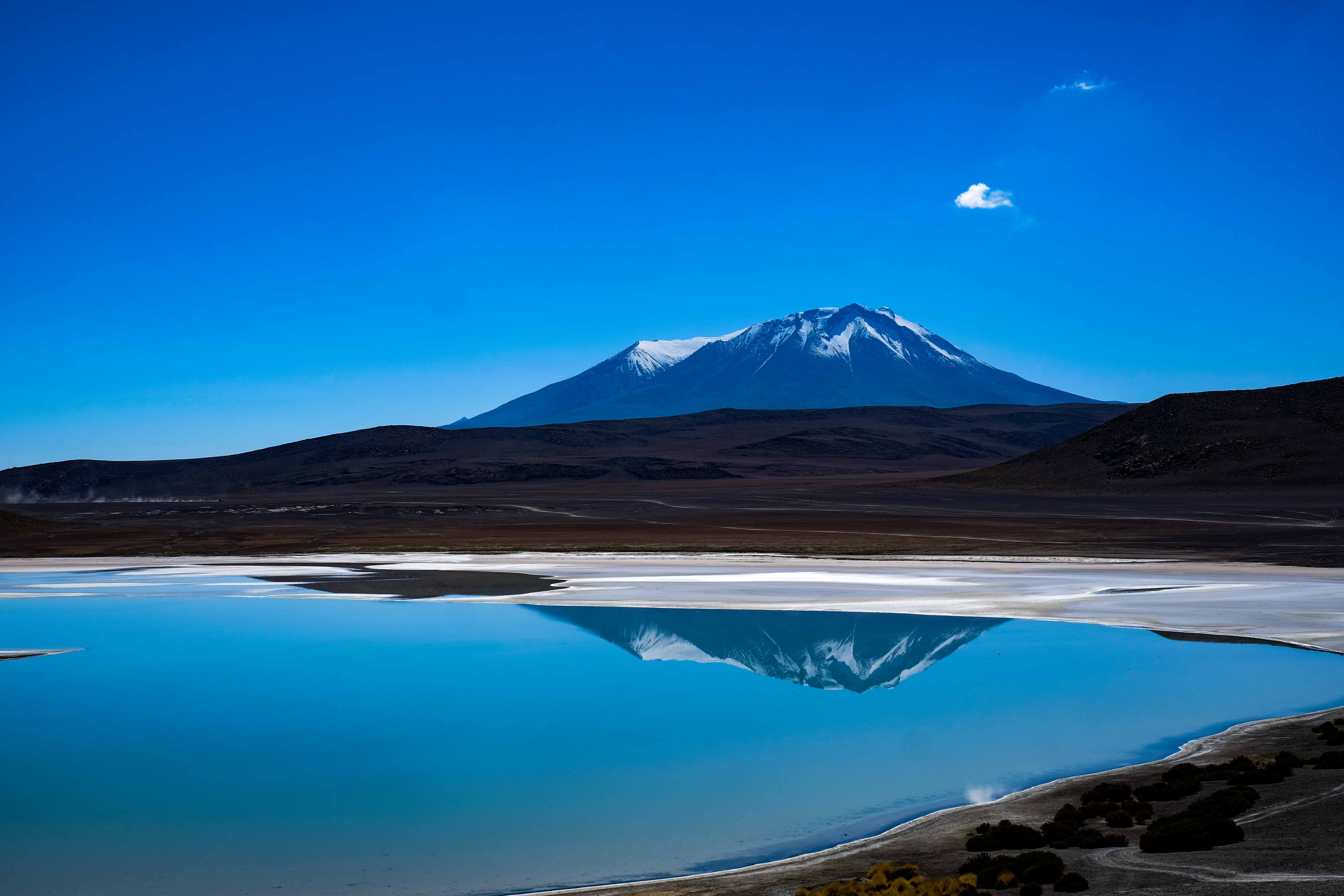 Snow-capped mountain reflected in a blue lake HD Wallpaper