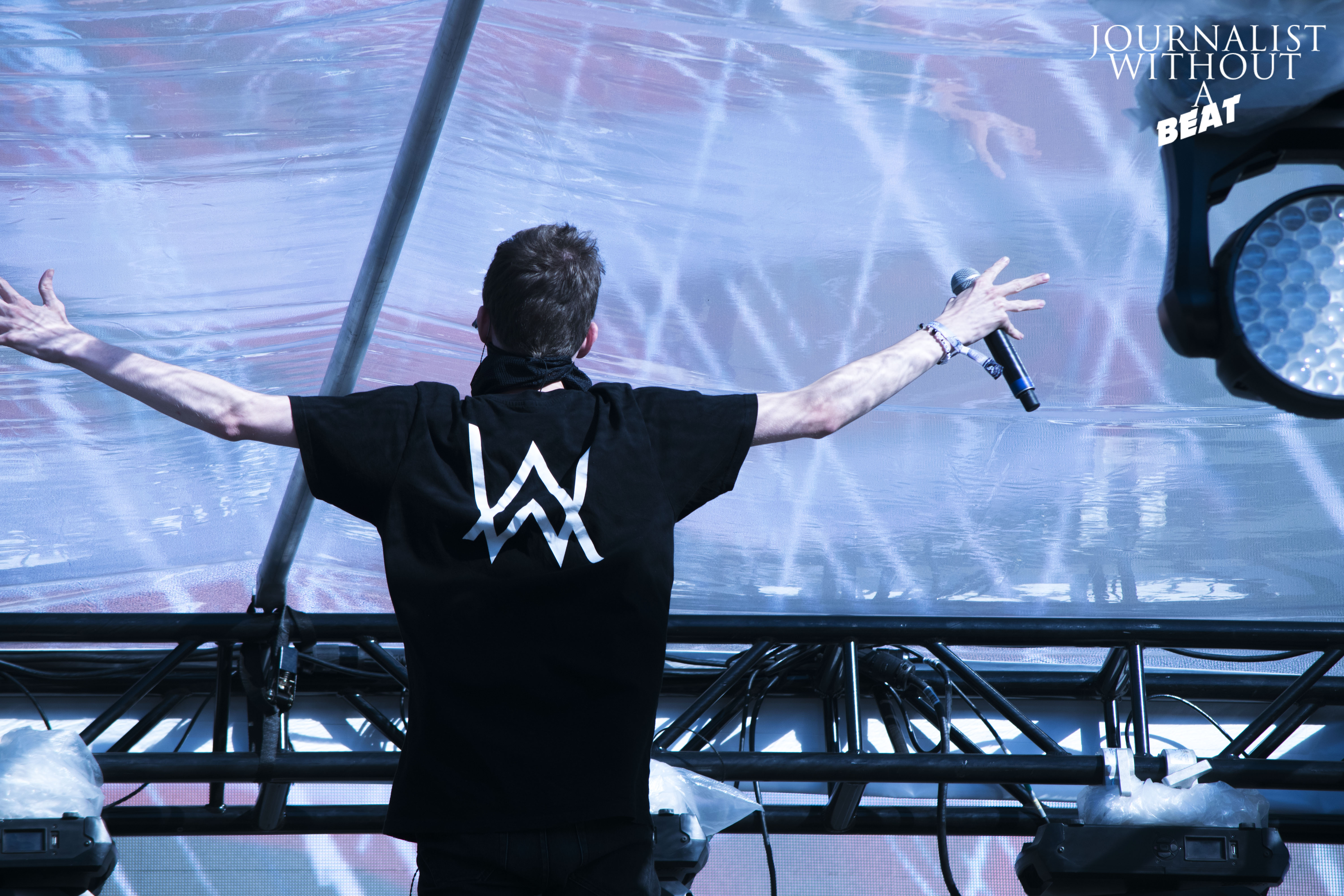 Alan Walker performing on stage with a microphone HD Wallpaper