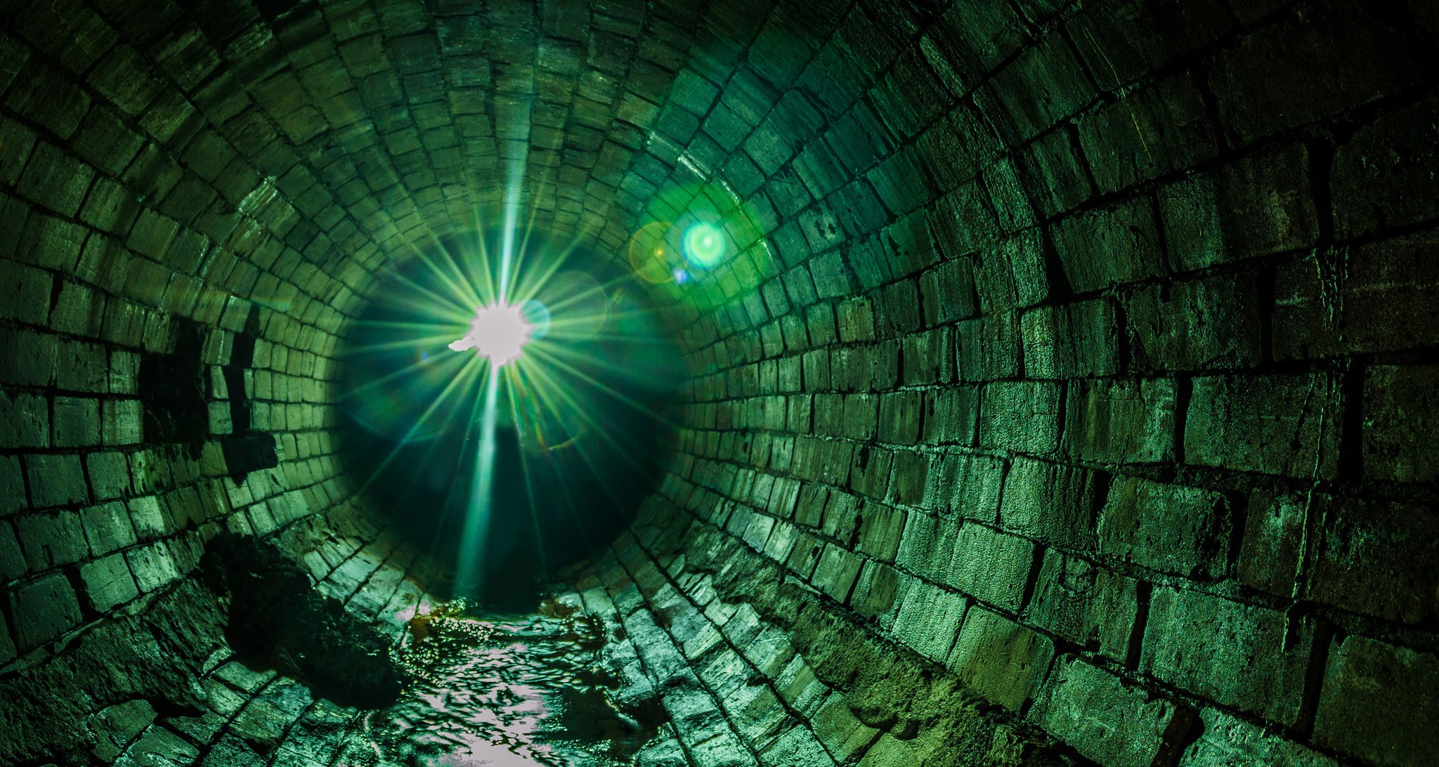 Green brick tunnel with light source HD Wallpaper