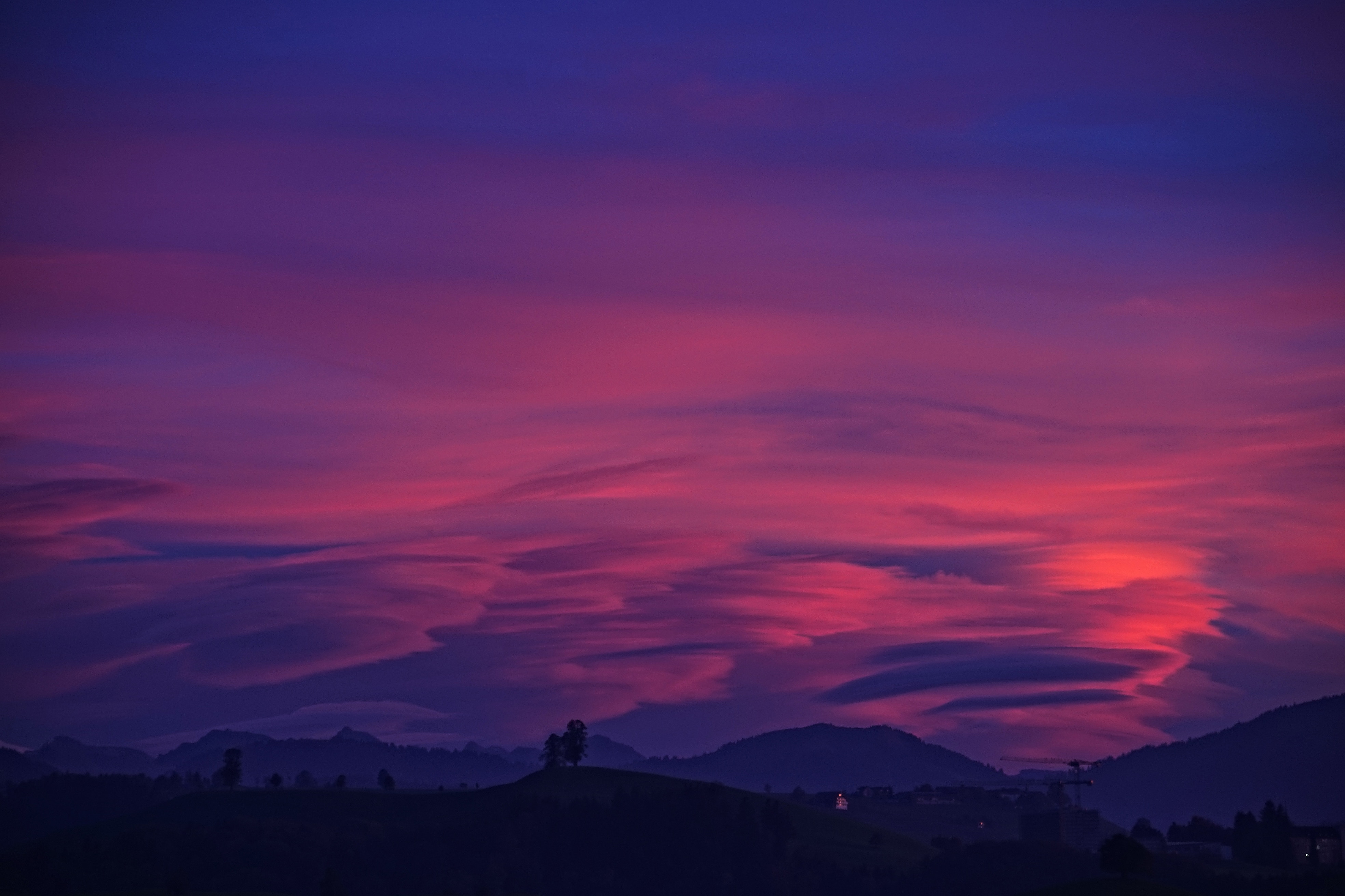 Pink and purple clouds over mountains at dusk 4K HD Wallpaper