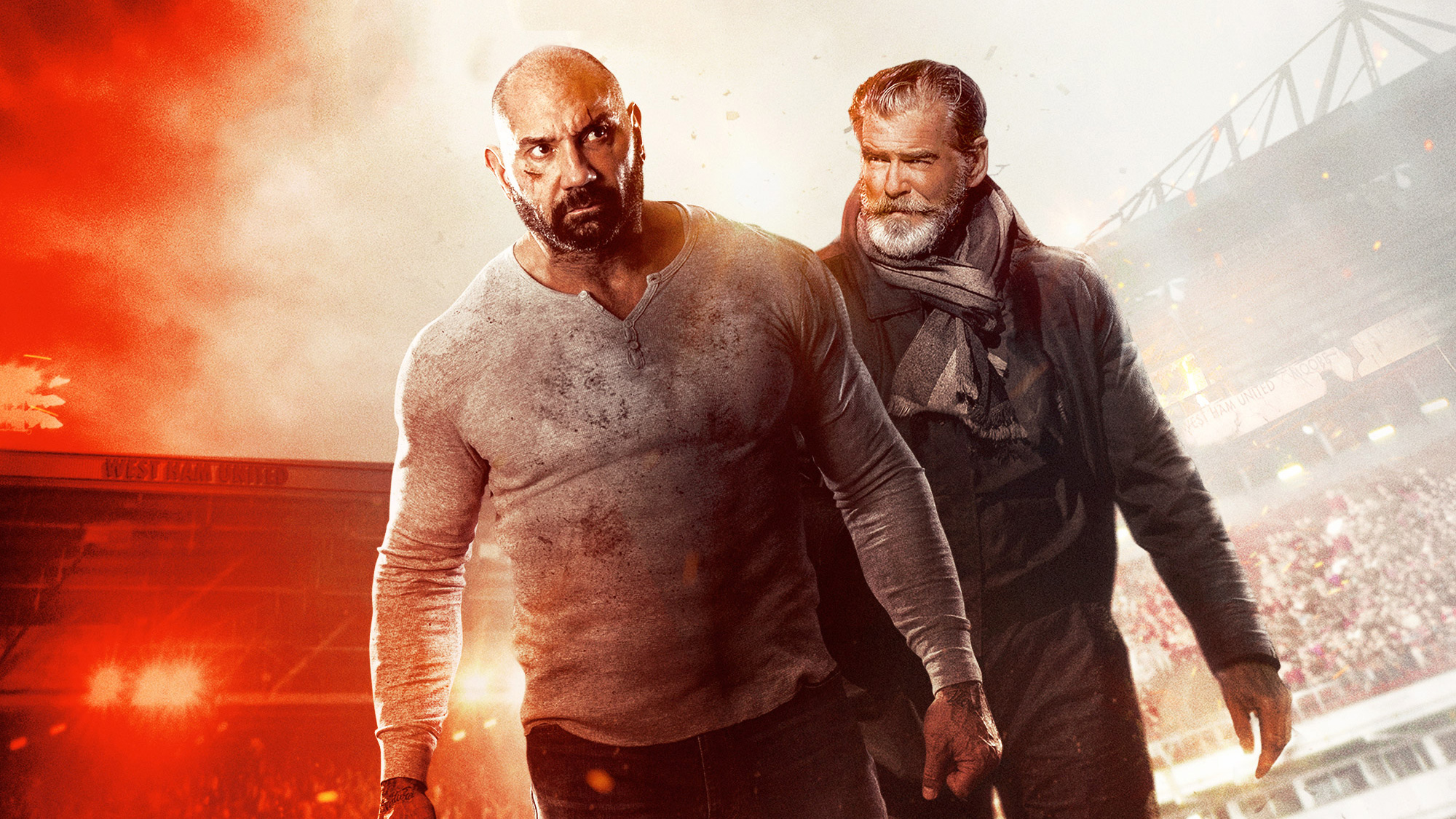Dave Bautista and Pierce Brosnan in a stadium HD Wallpaper