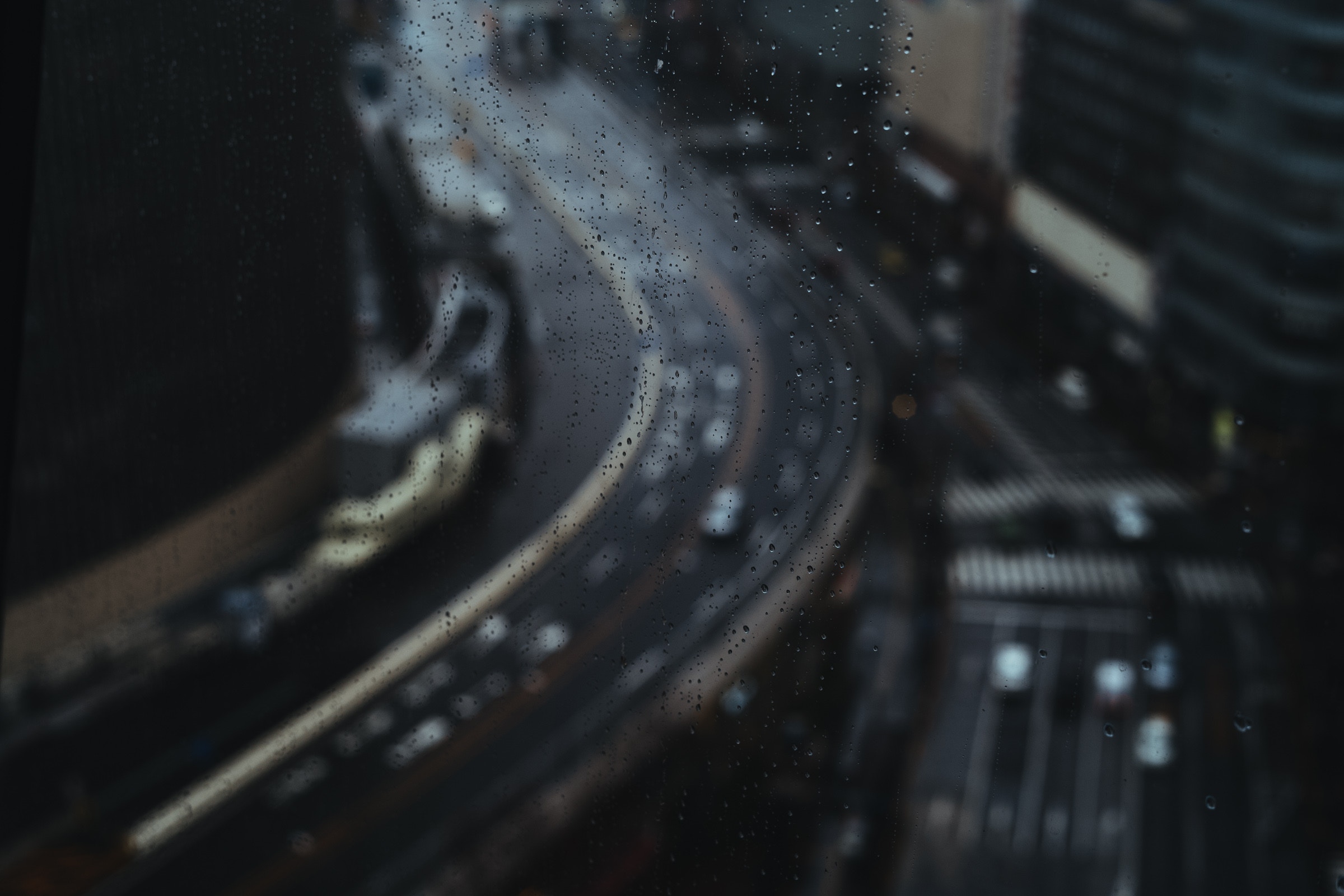 Raindrops on glass overlooking a busy highway HD Wallpaper