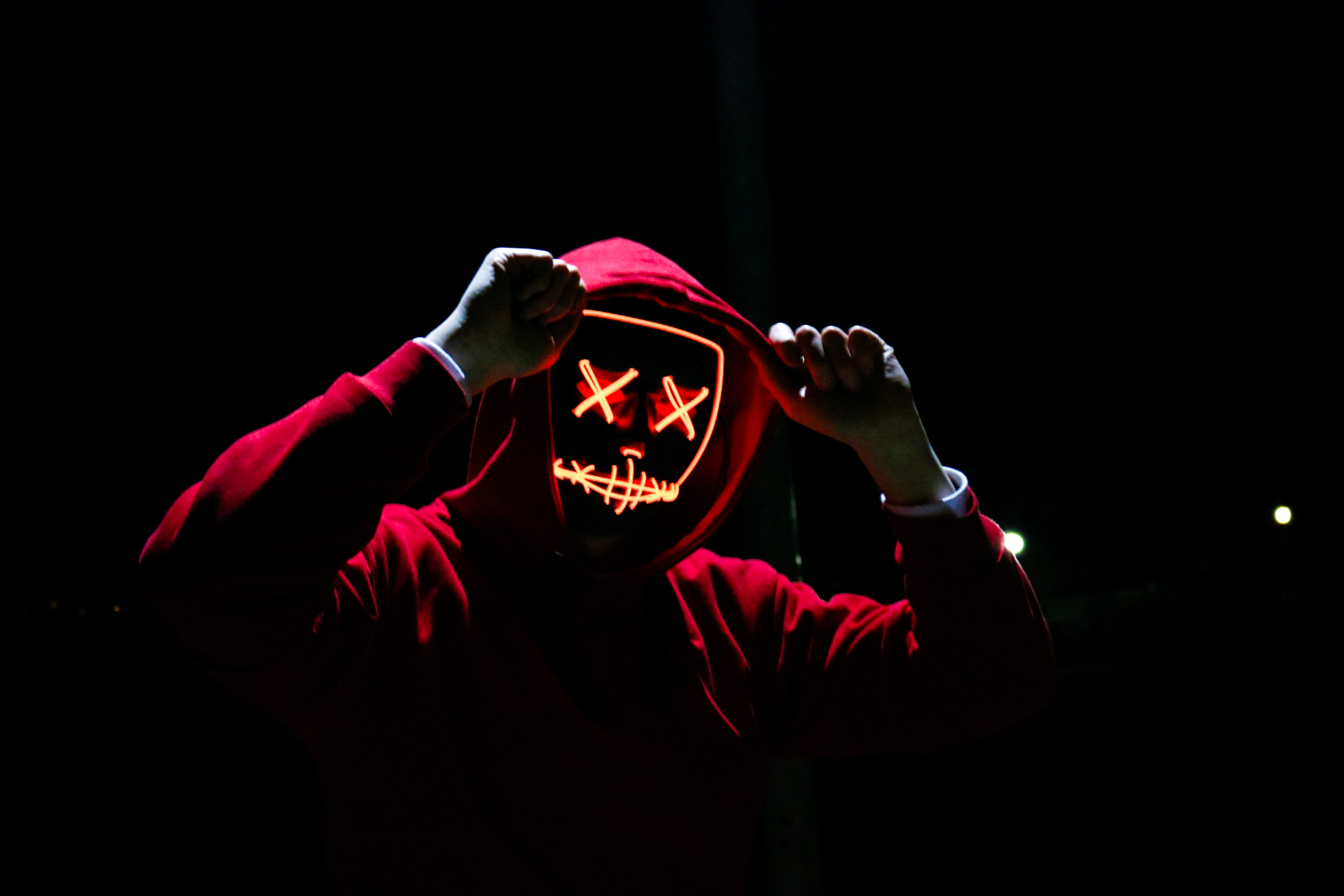 Person in red hoodie wearing a neon mask HD Wallpaper