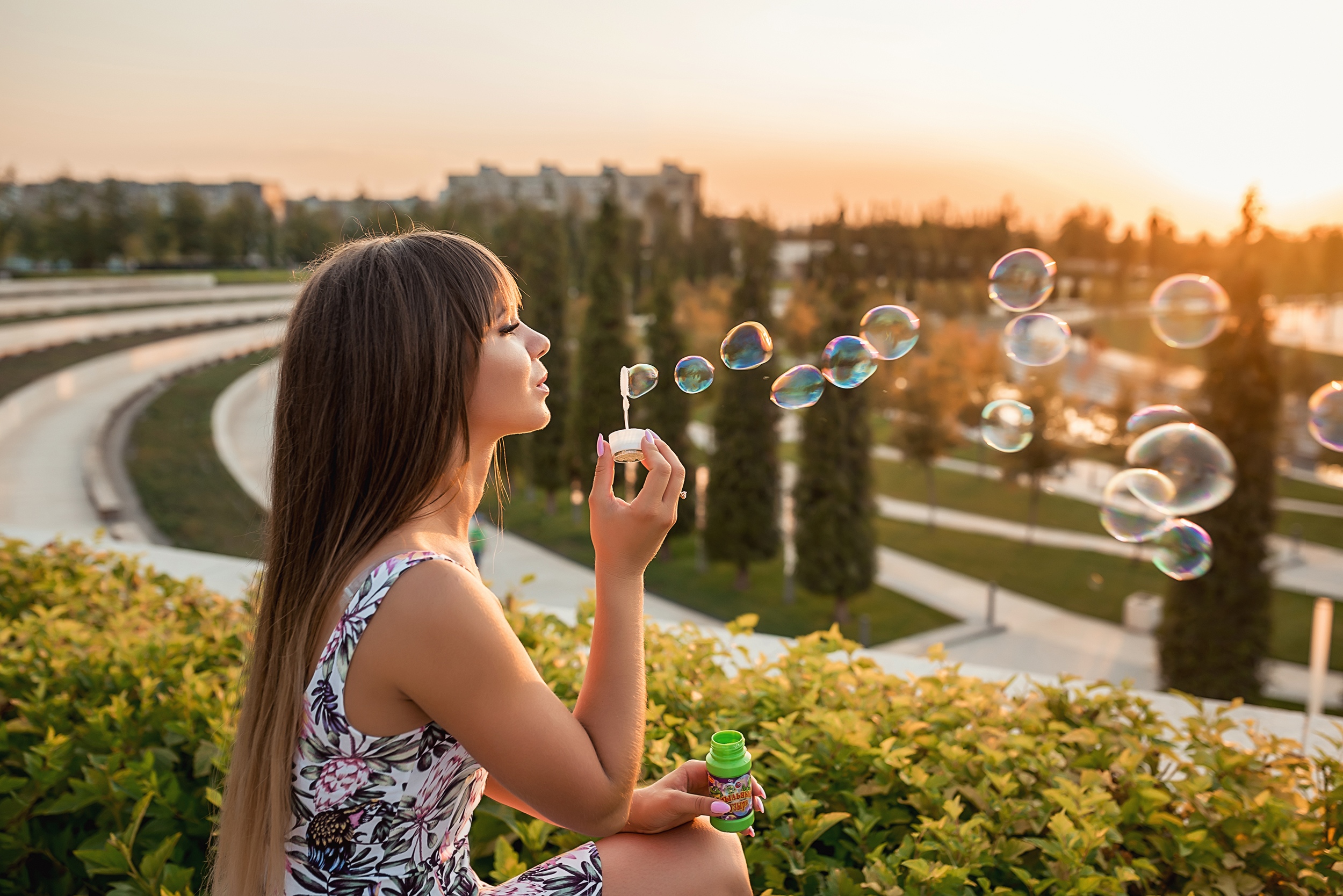 Girl blowing bubbles outdoors at sunset HD Wallpaper