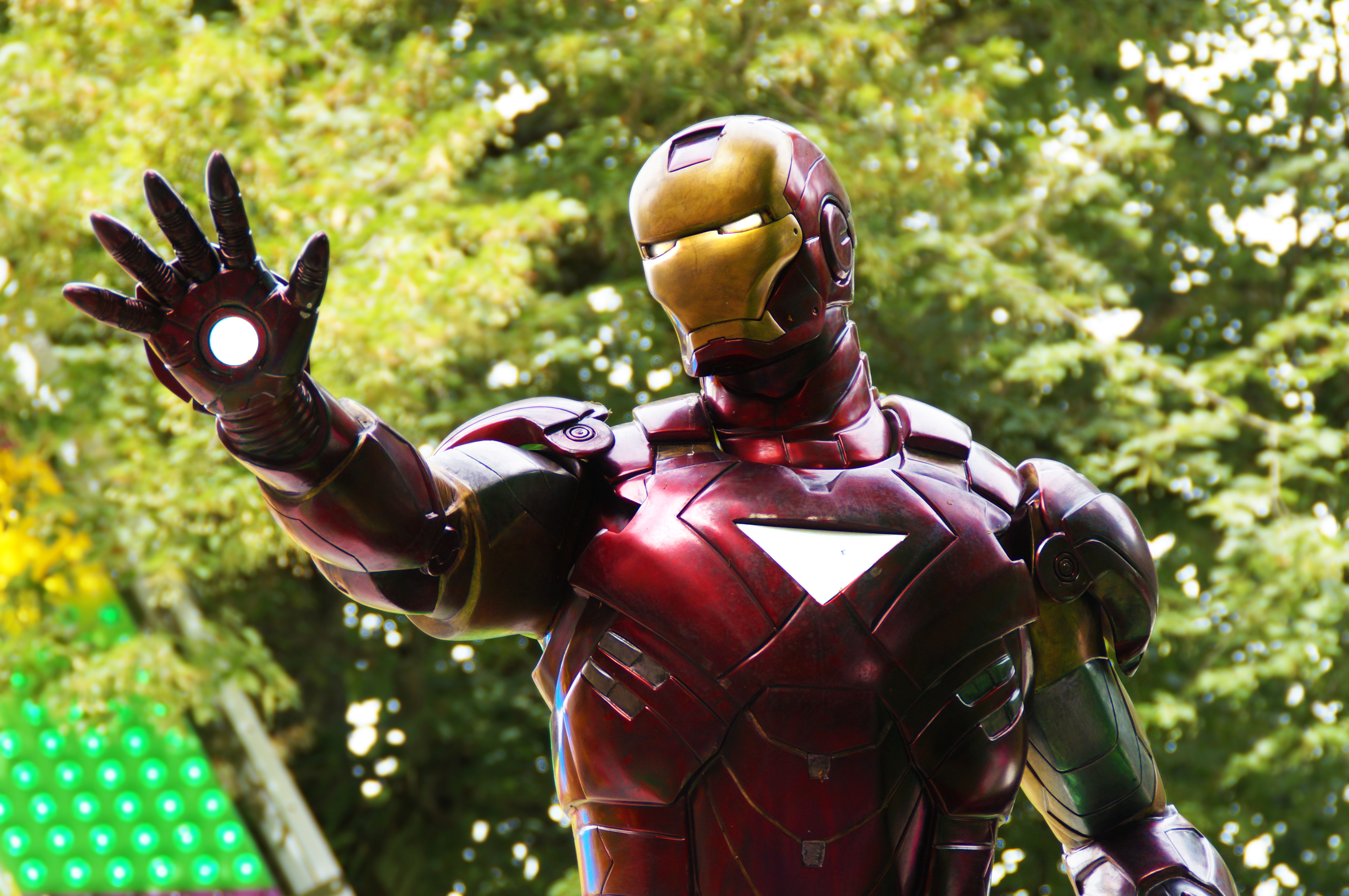 Iron Man with glowing hand in front of trees HD Wallpaper