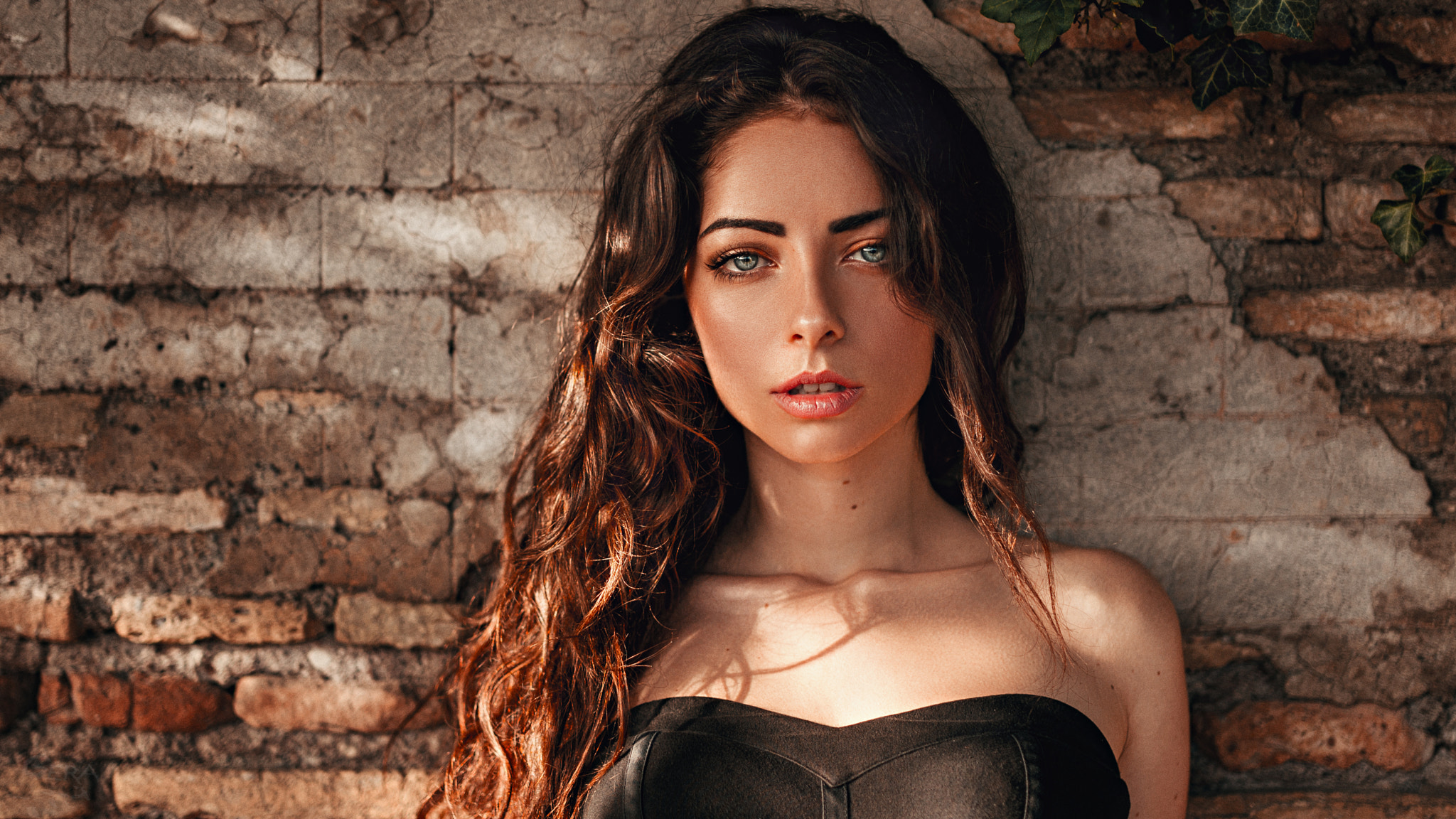 Portrait of a Woman with Long Wavy Hair by Brick Wall HD Wallpaper