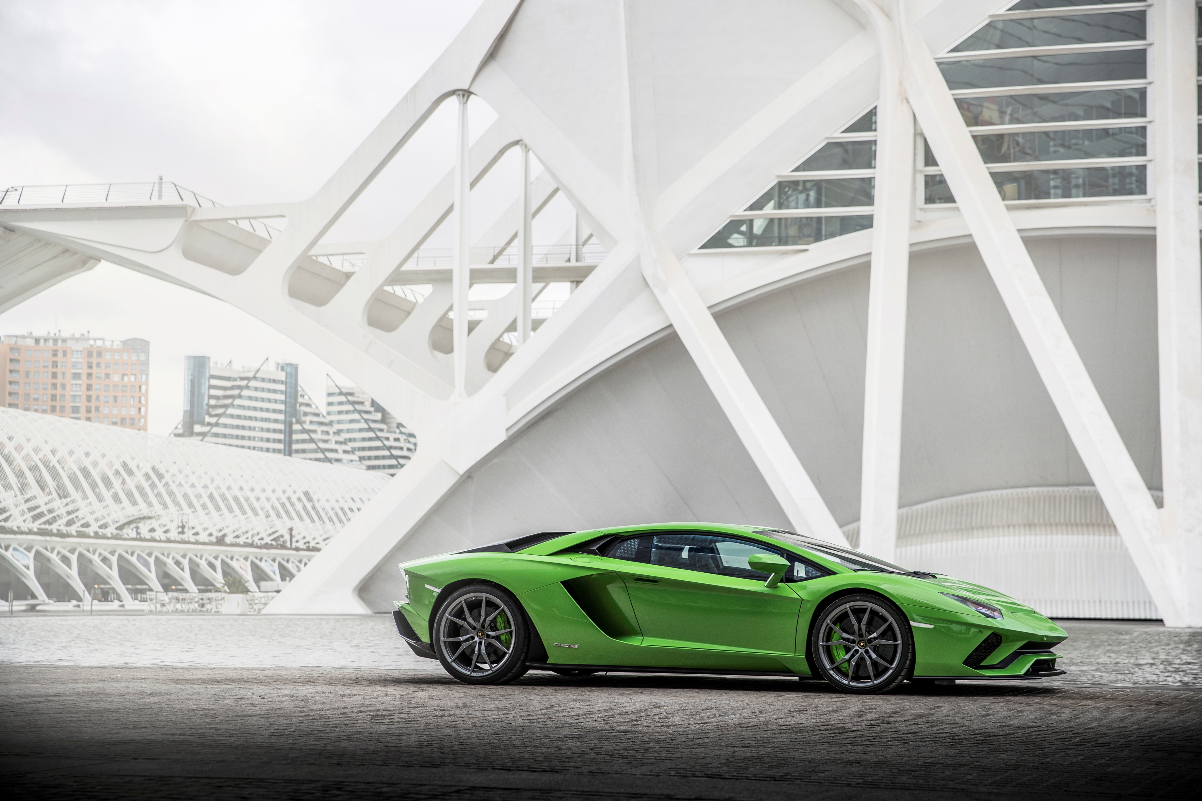 Green Lamborghini Aventador S parked near modern architecture HD Wallpaper