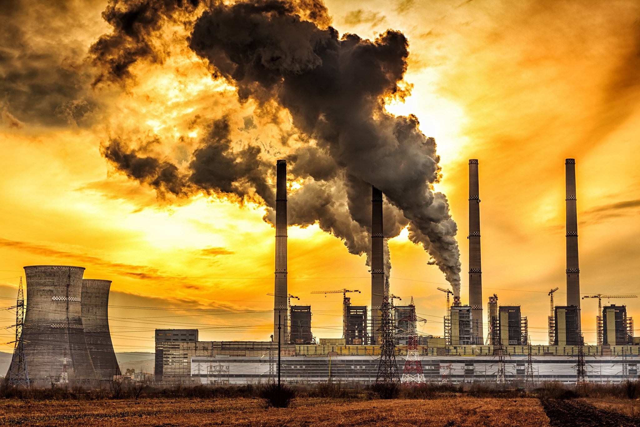 Factory with smoke stacks and cooling towers HD Wallpaper