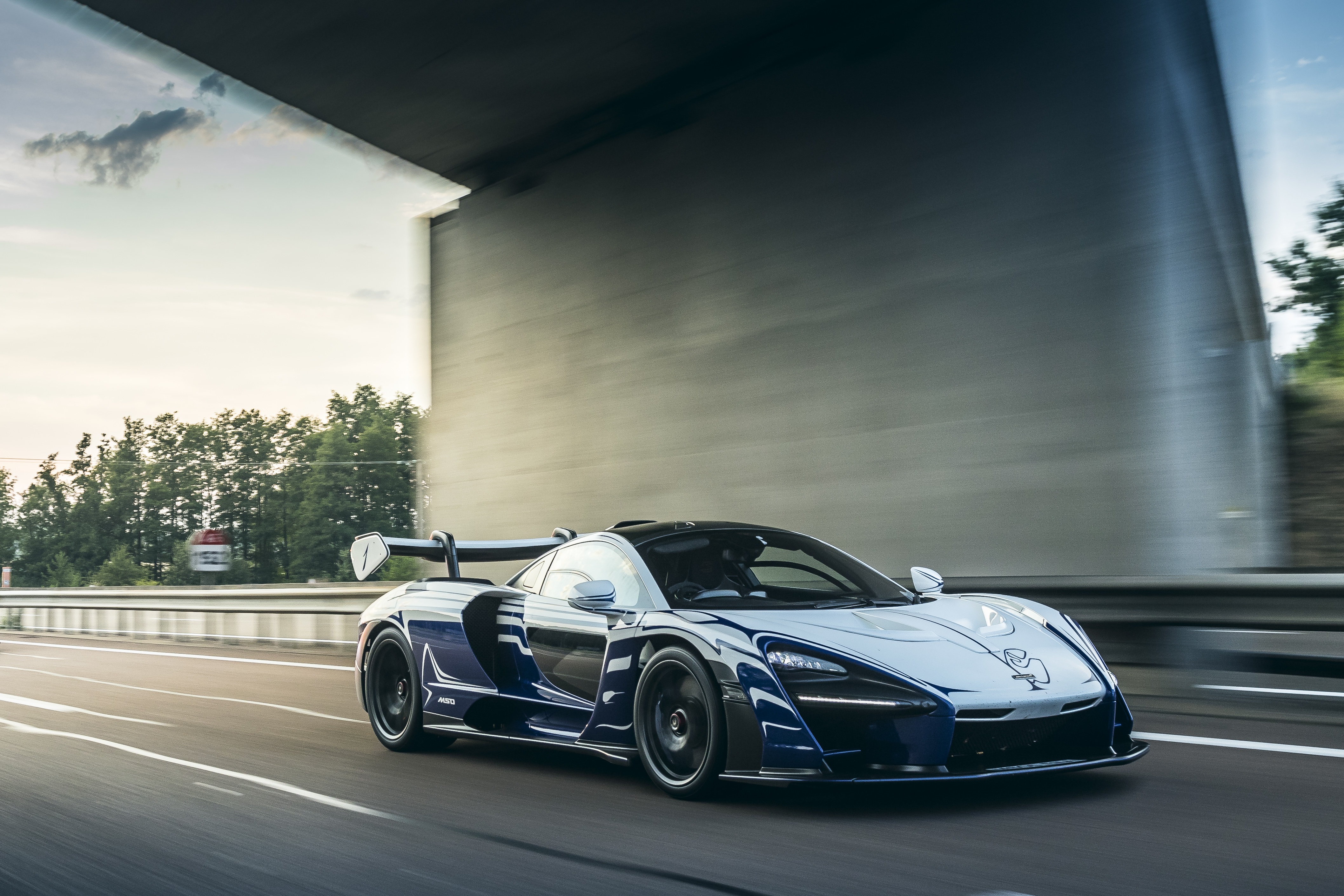 McLaren Senna driving on a highway under a bridge HD Wallpaper