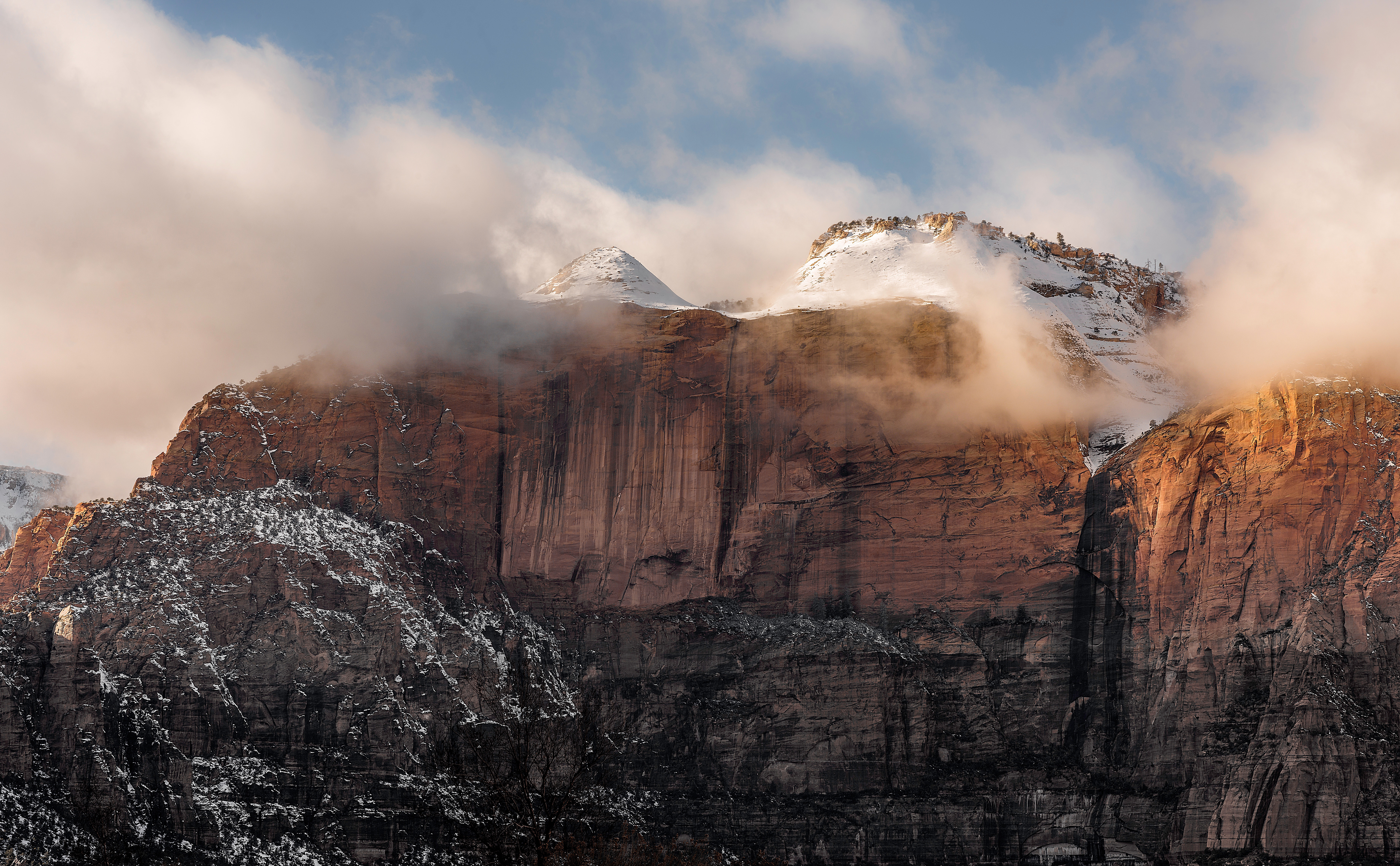 Sunlit Mountain Peaks with Glowing Clouds in 4K HD Wallpaper