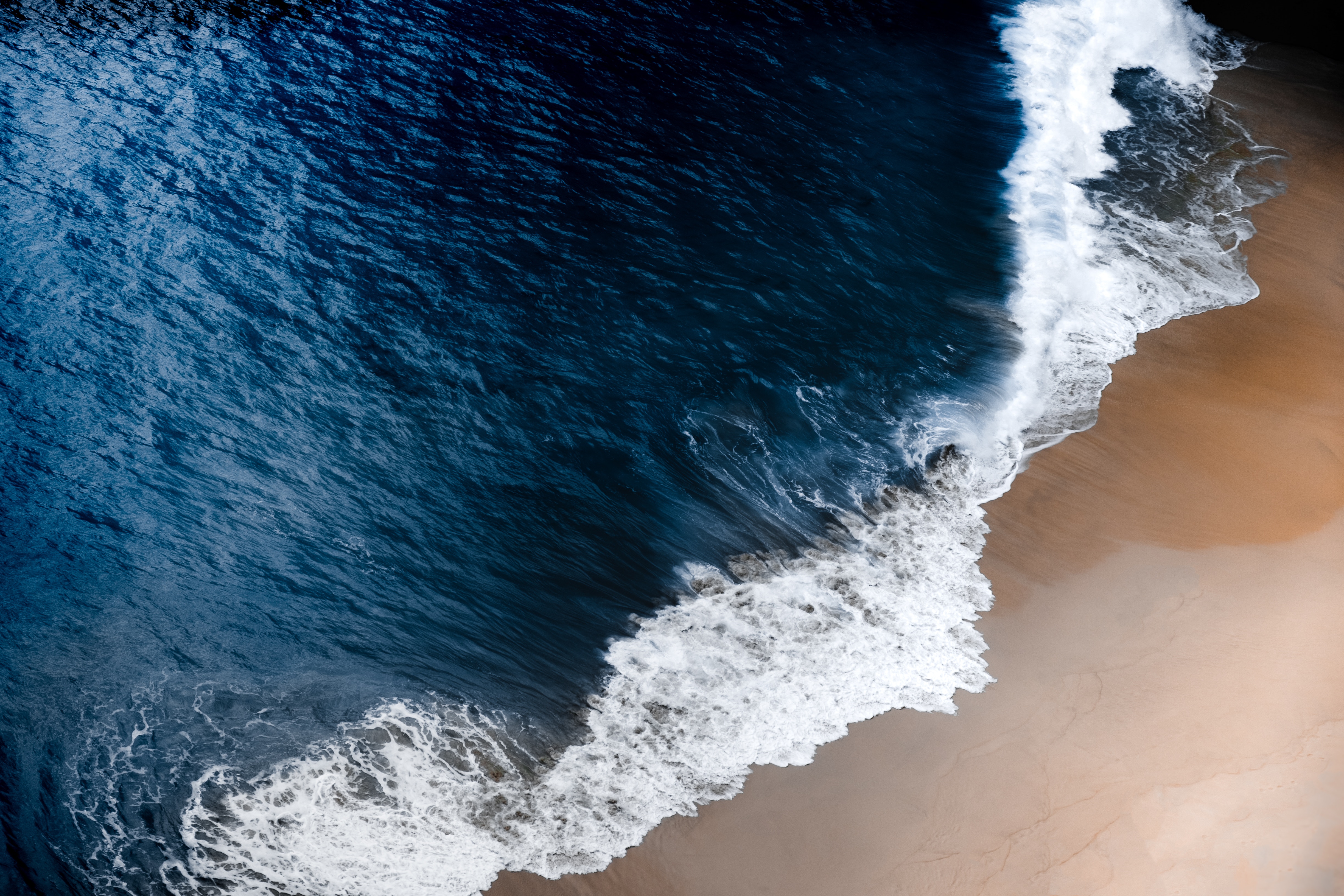 Ocean waves crashing on a sandy beach 4K HD Wallpaper
