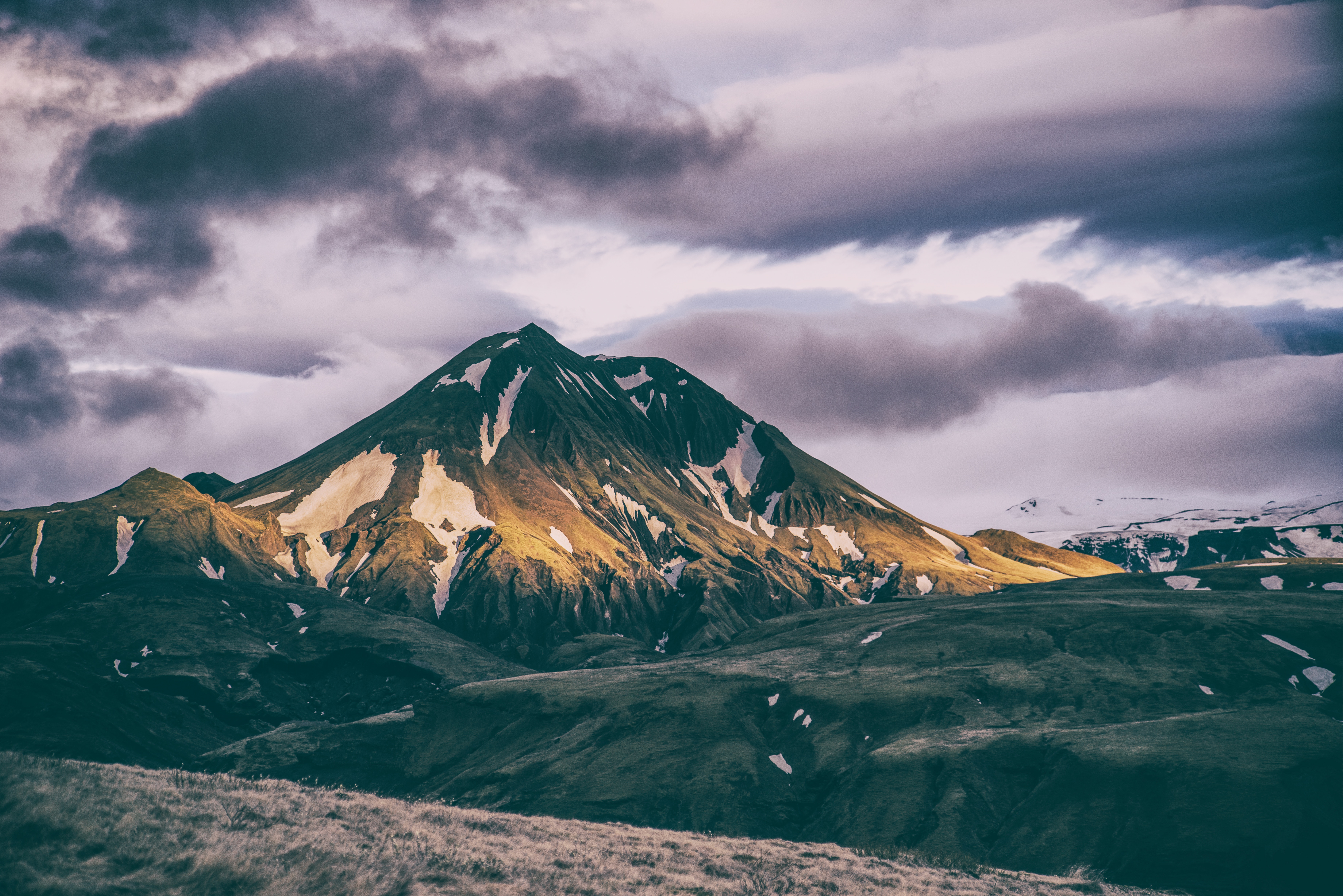 Mountains landscape with snow patches under cloudy sky HD Wallpaper