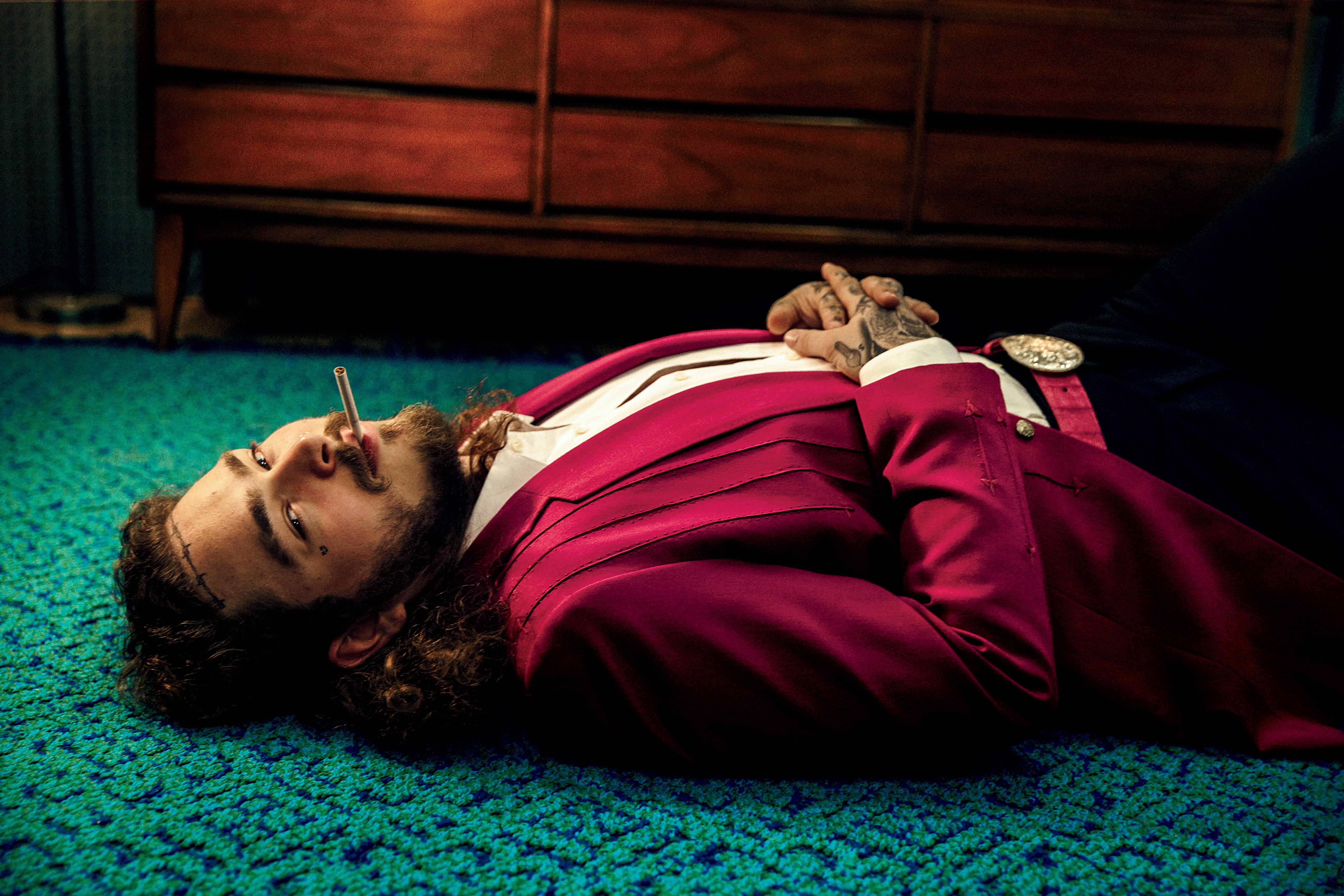 Post Malone lying on a carpet smoking HD Wallpaper