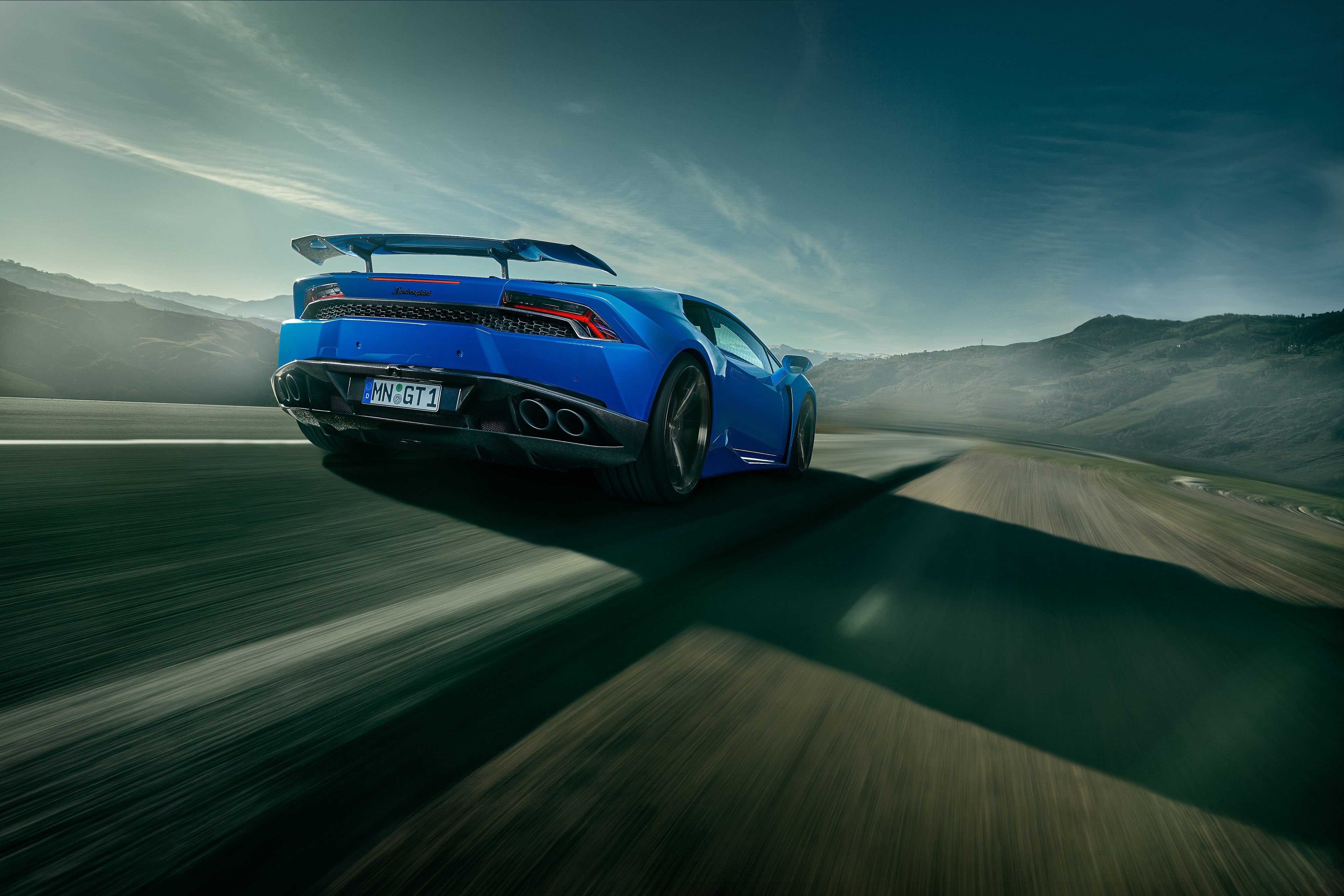 Blue Lamborghini Huracan driving on a road HD Wallpaper
