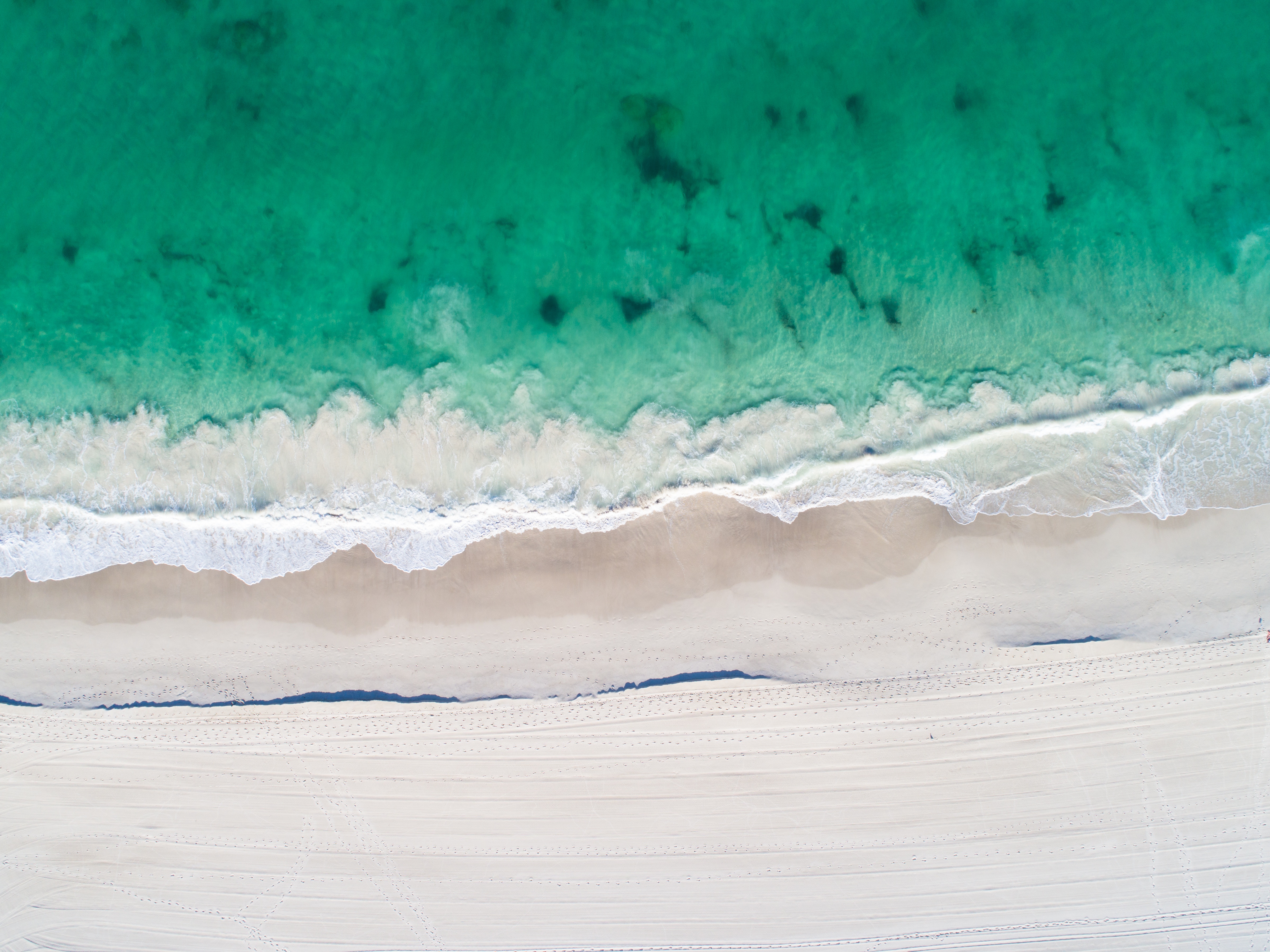 Aerial view of a tropical beach with turquoise ocean waves HD Wallpaper