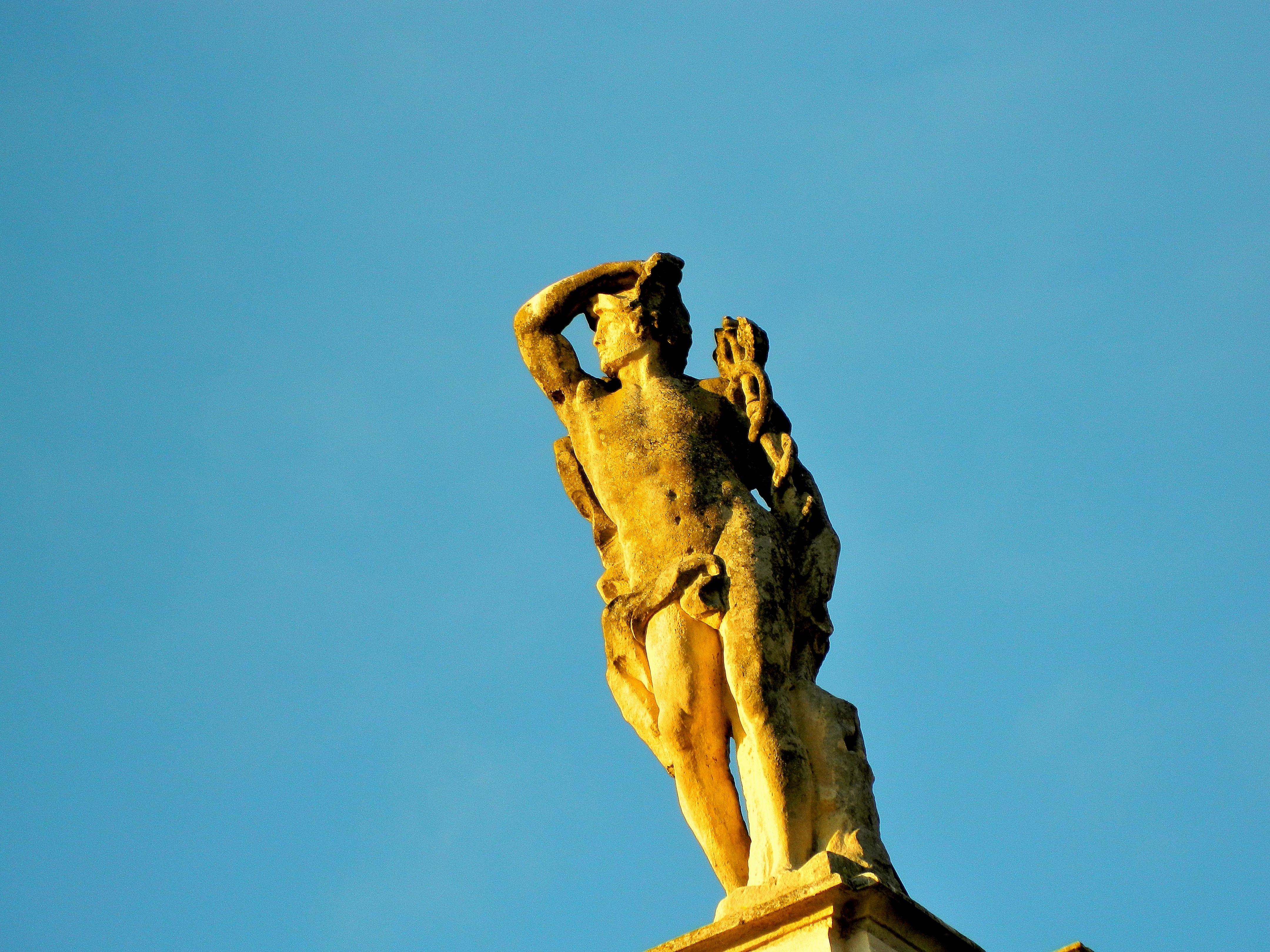 Statue of a man against a blue sky HD Wallpaper