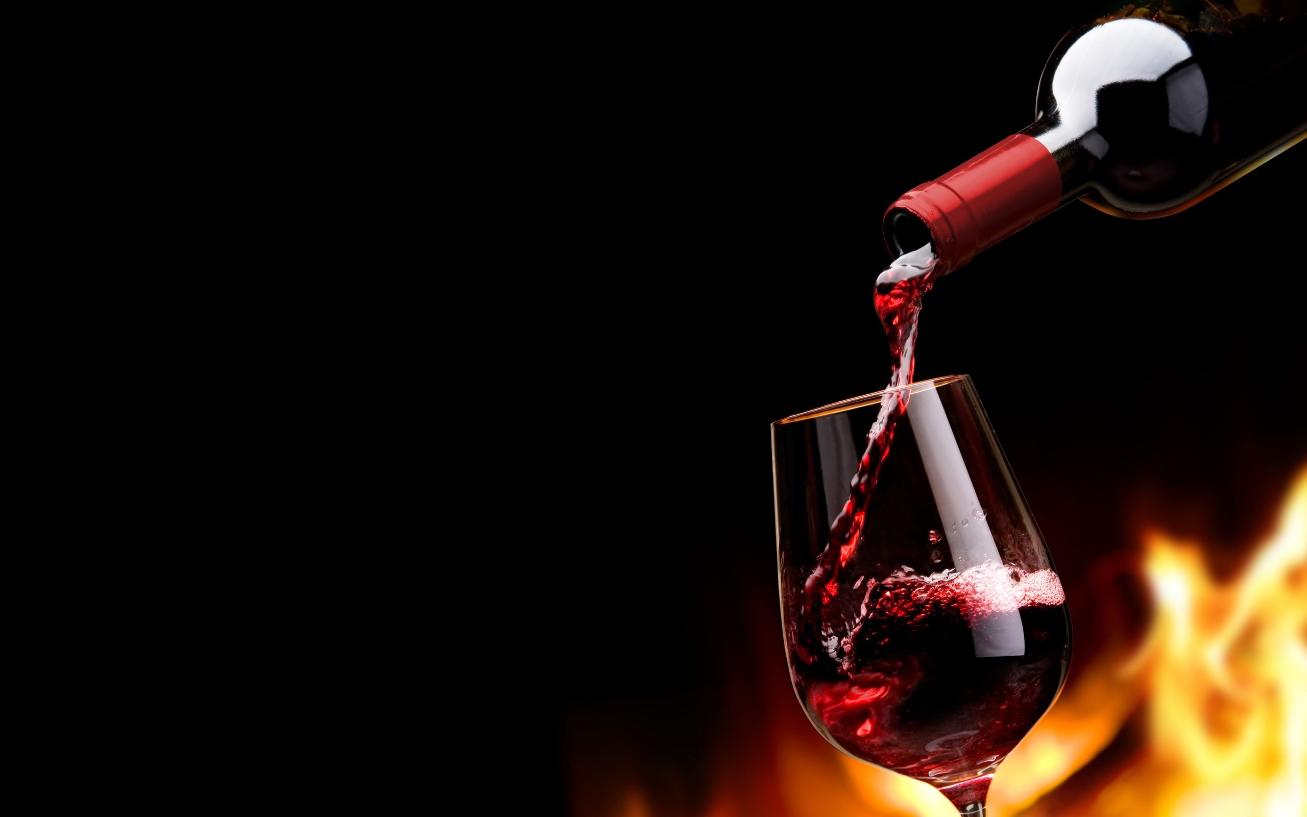 Red wine being poured from bottle into glass with flames HD Wallpaper