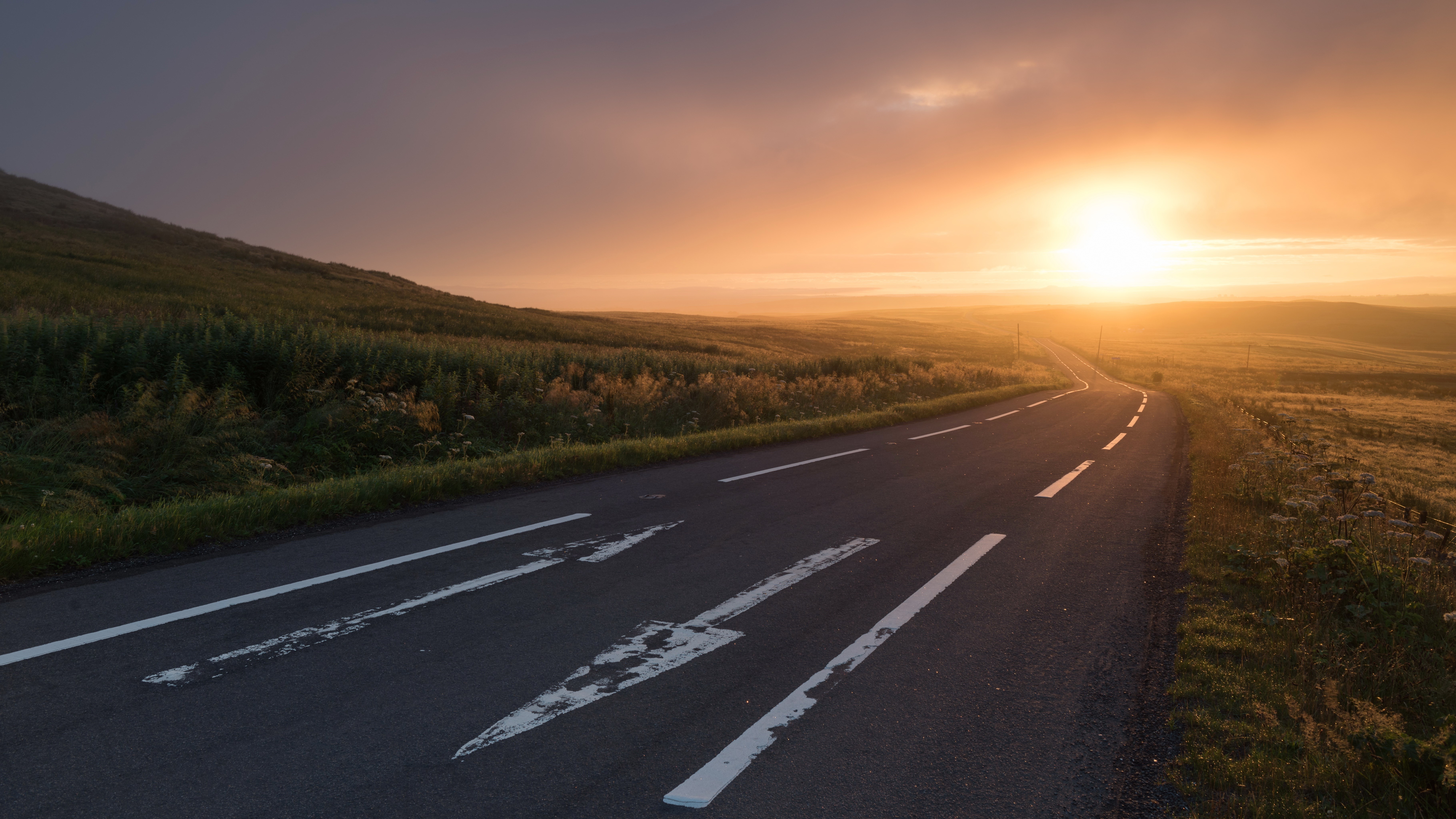 Road winding through hills at sunrise HD Wallpaper