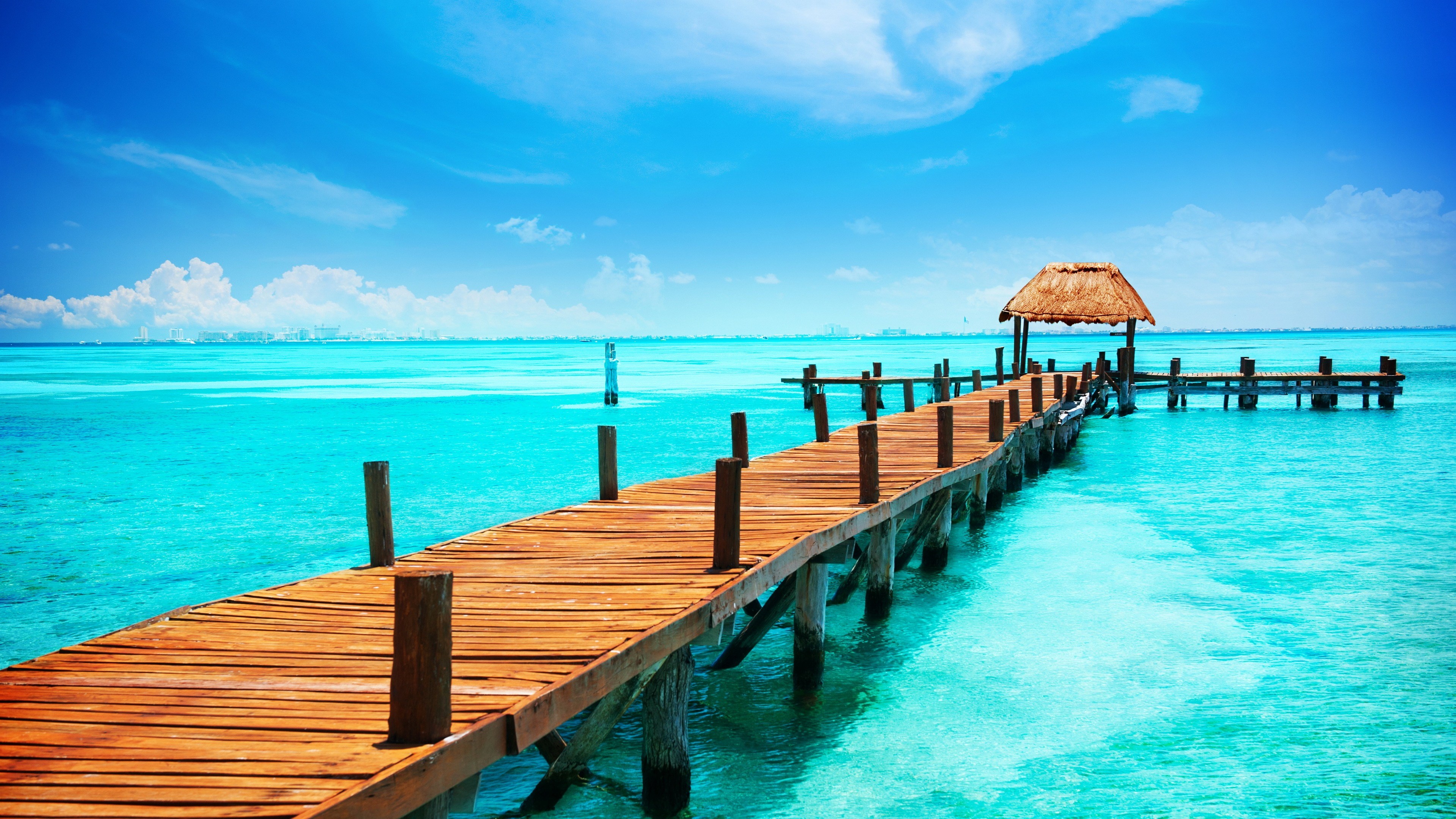 Wooden pier on turquoise water under blue sky HD Wallpaper