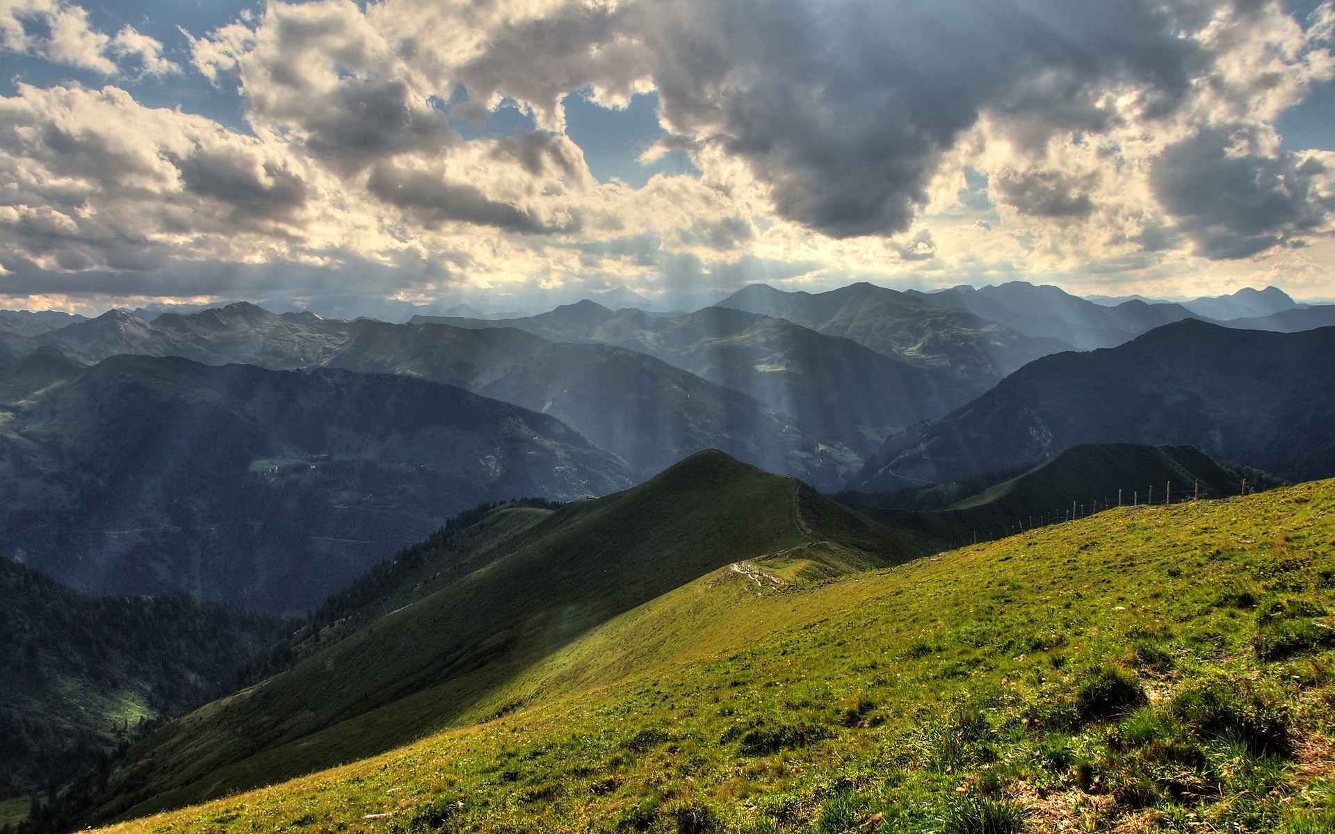 Sunbeams through clouds over mountain range HD Wallpaper