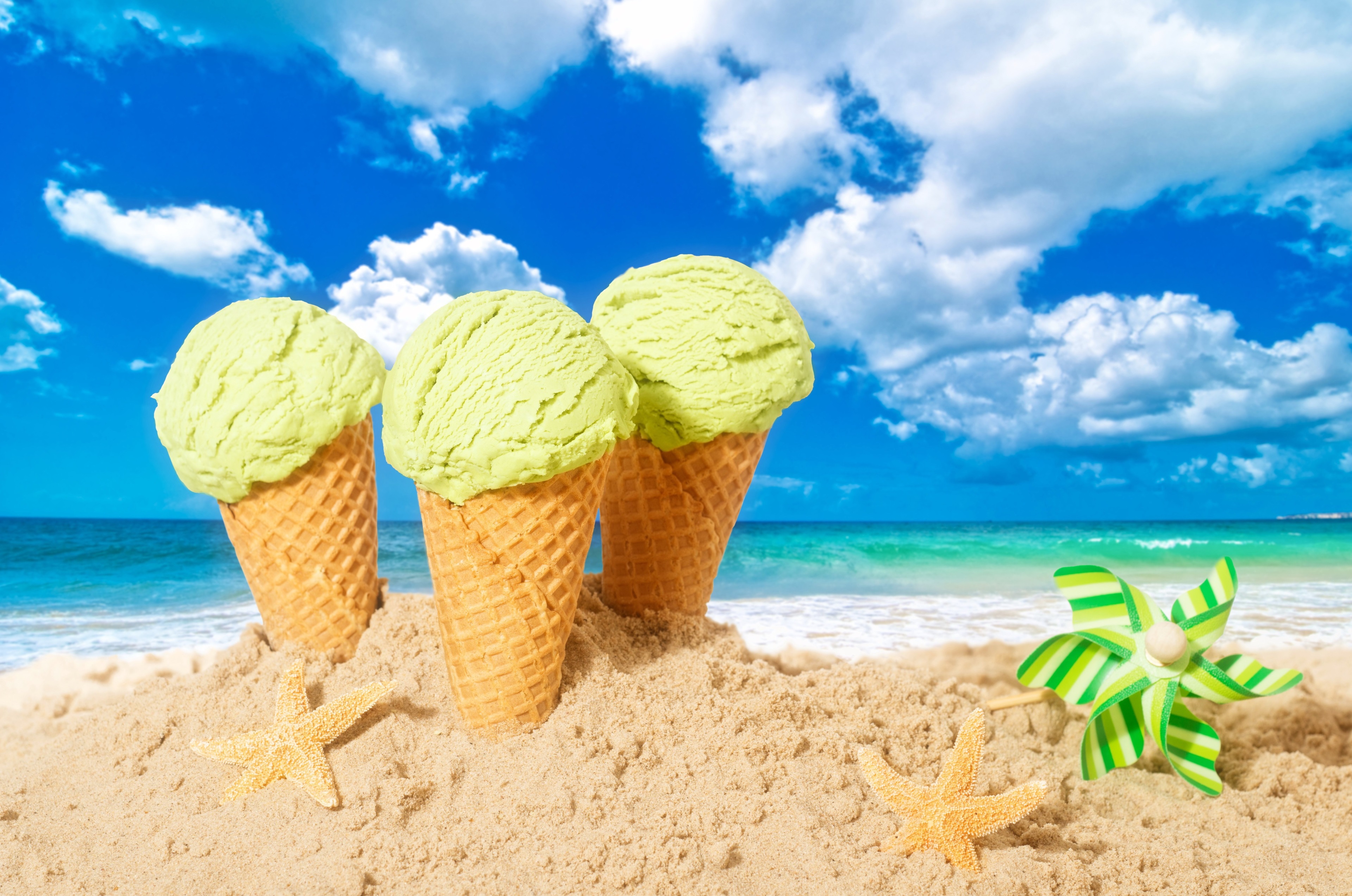 Three ice cream cones on a beach with starfish and pinwheel HD Wallpaper