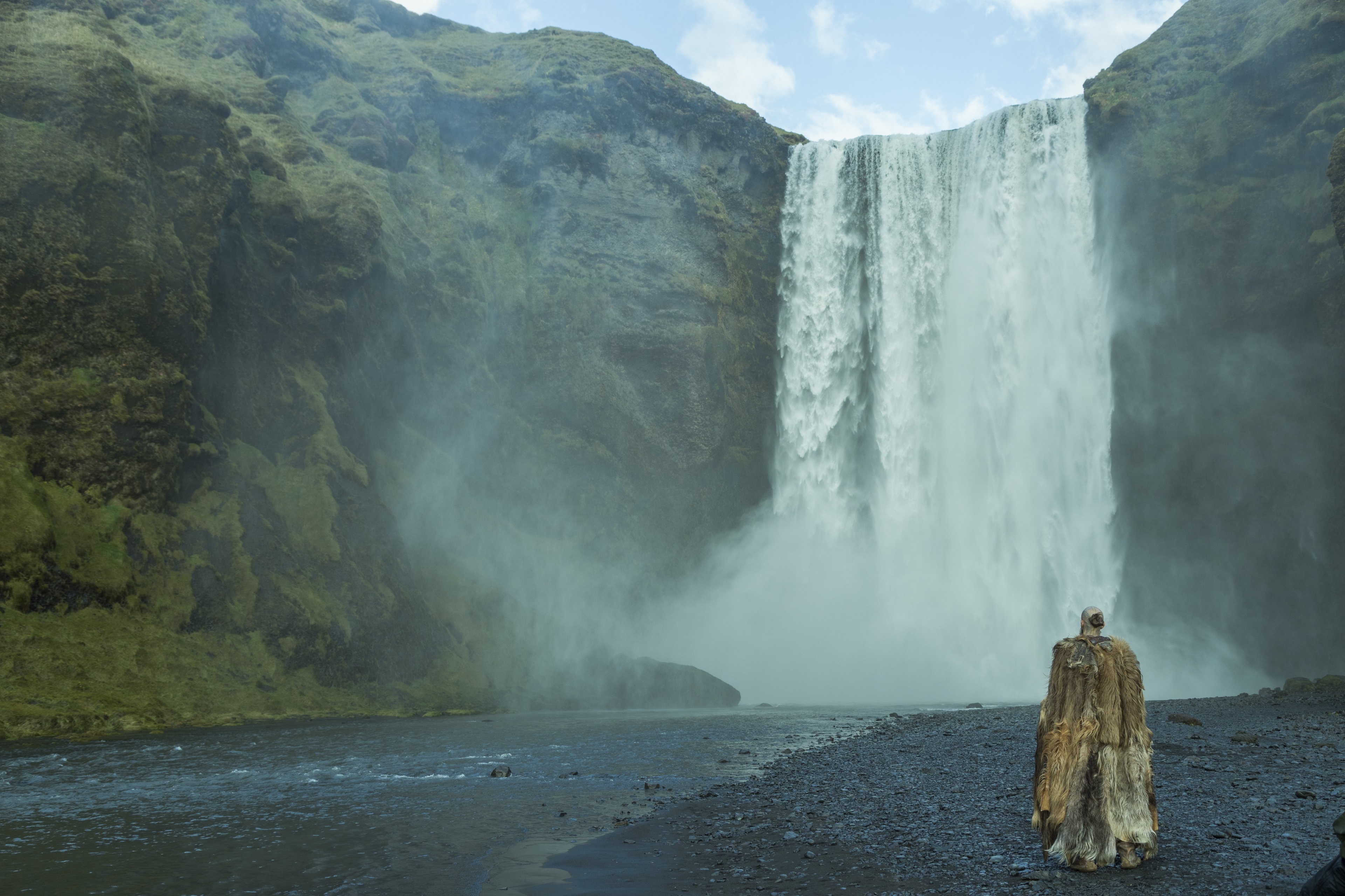 Man in fur cloak at Skogafoss waterfall, Iceland HD Wallpaper