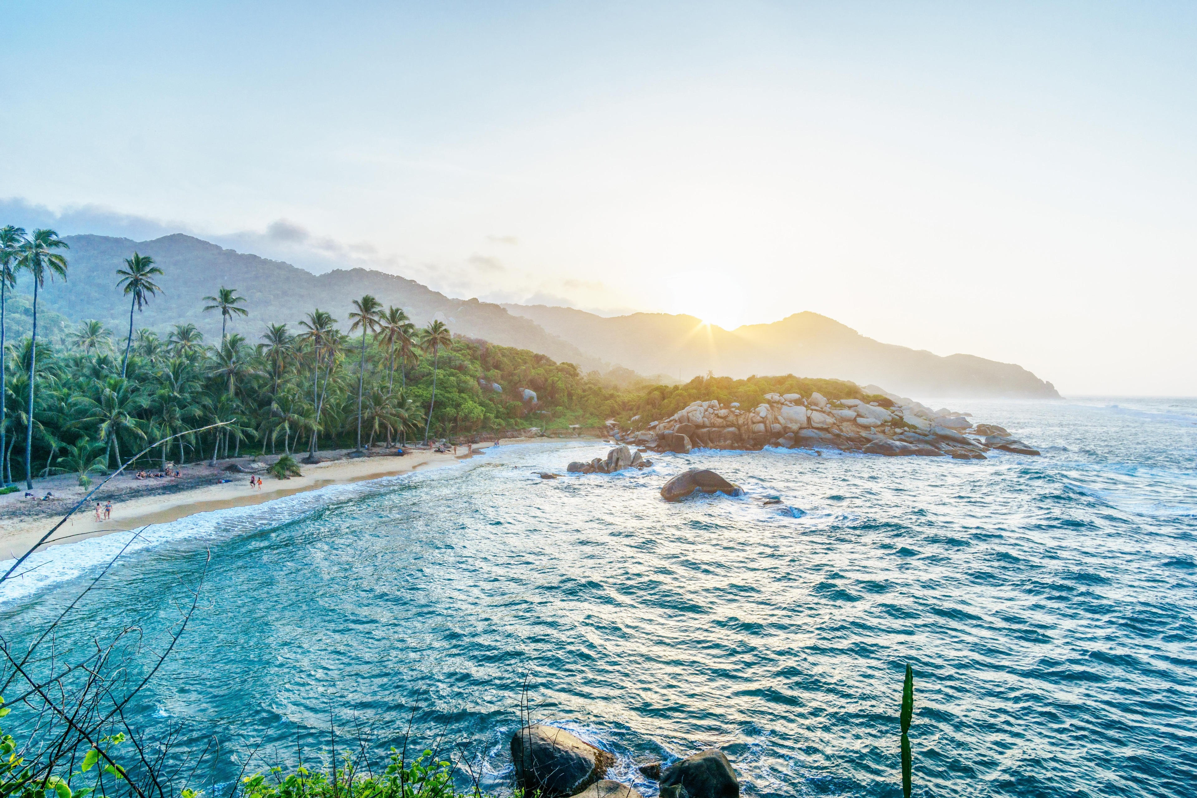 Beach with palm trees and mountains at sunset HD Wallpaper