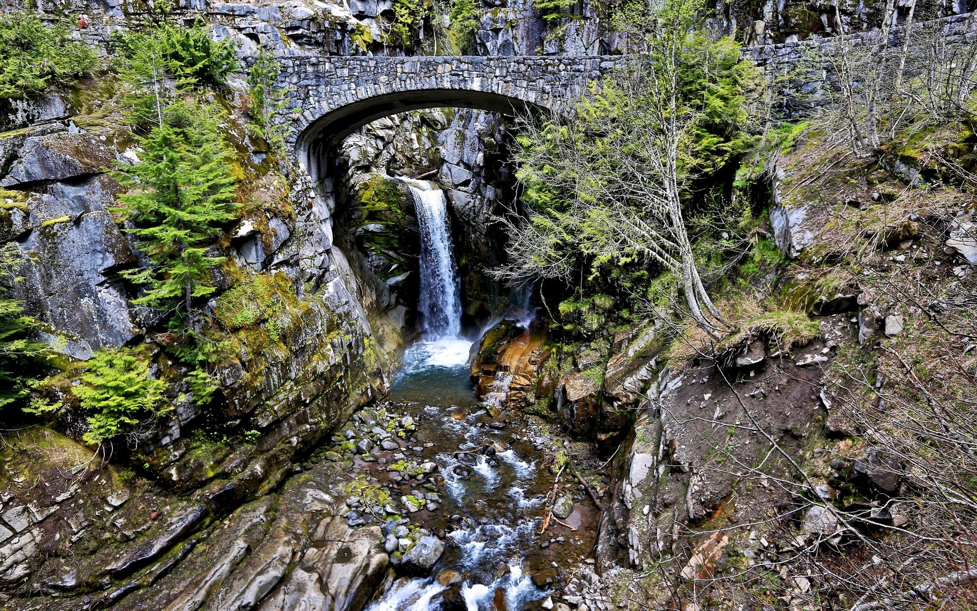 Stone bridge over a waterfall and stream in a rocky gorge HD Wallpaper
