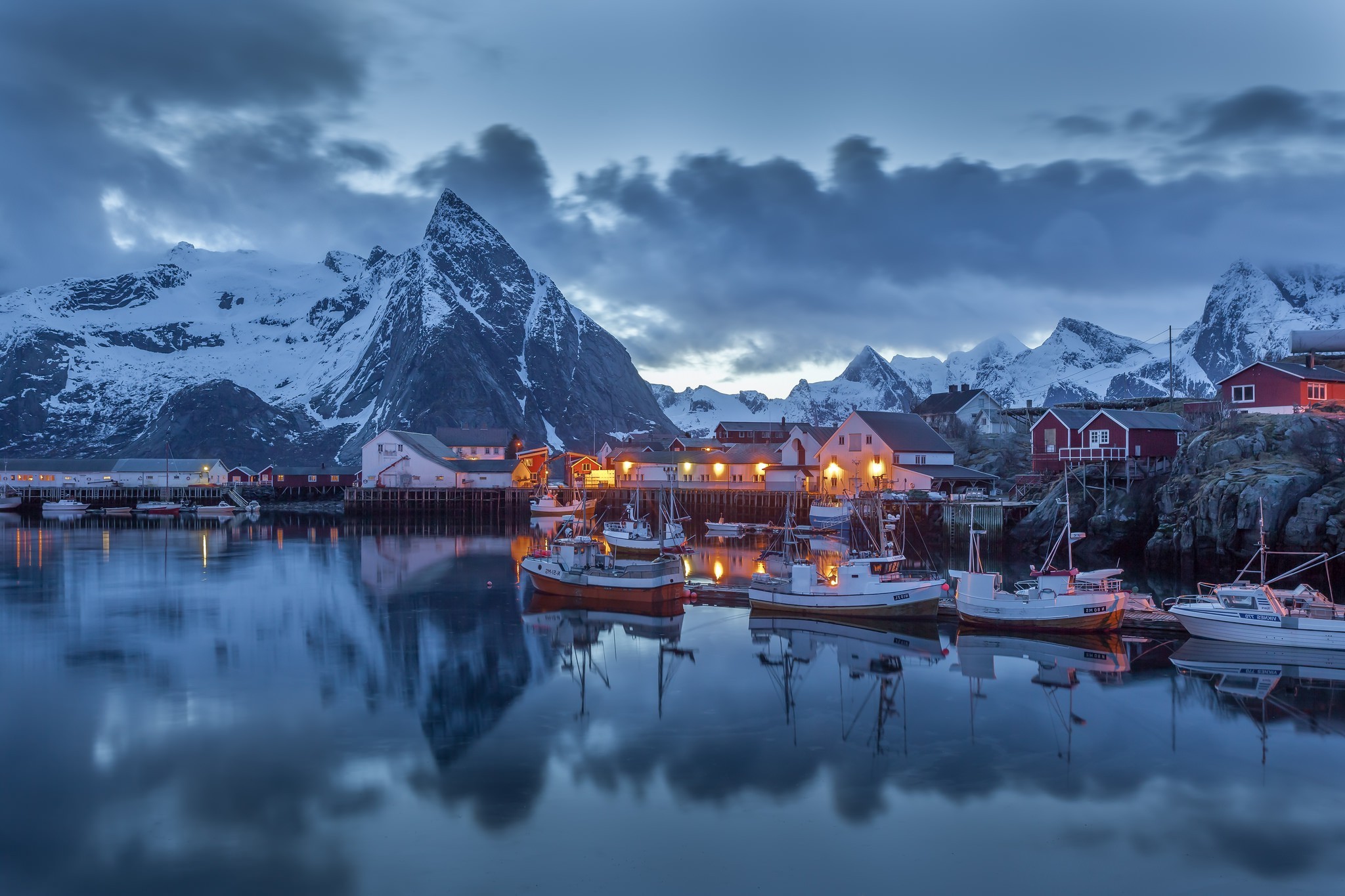 Fishing village and snow-capped mountains at dusk HD Wallpaper