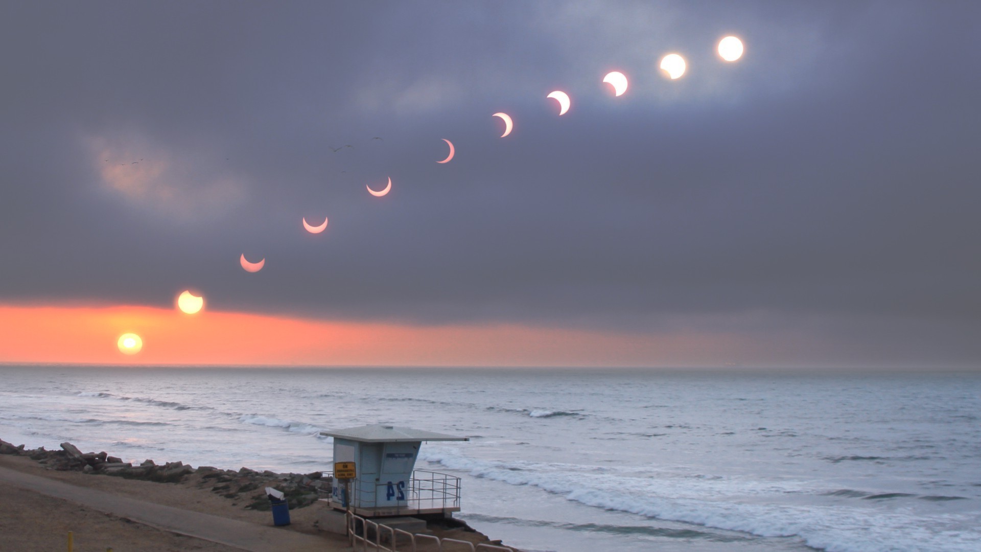 Solar eclipse over the ocean at sunset HD Wallpaper