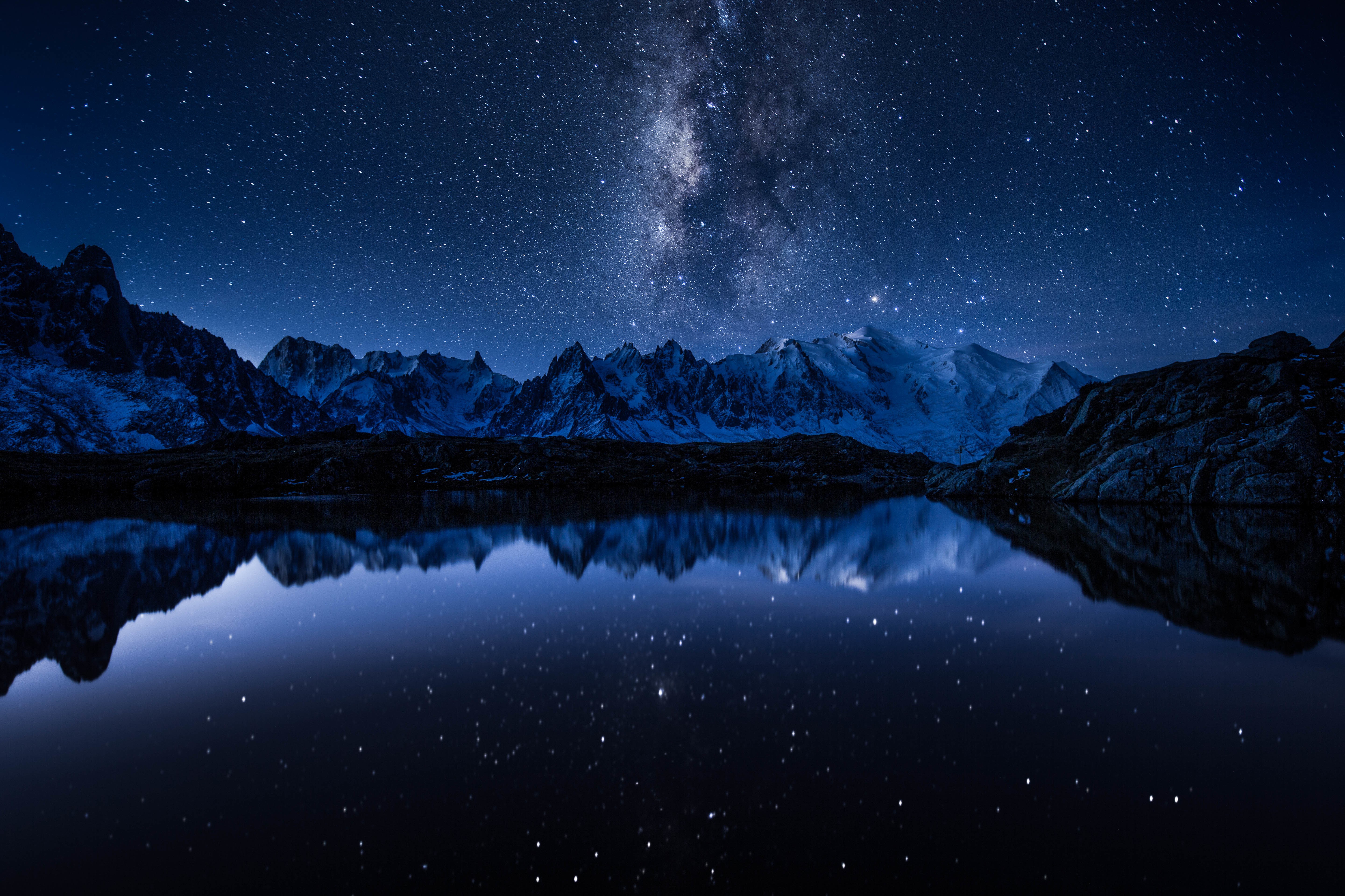 Milky Way over snow-capped mountains reflected in a lake HD Wallpaper