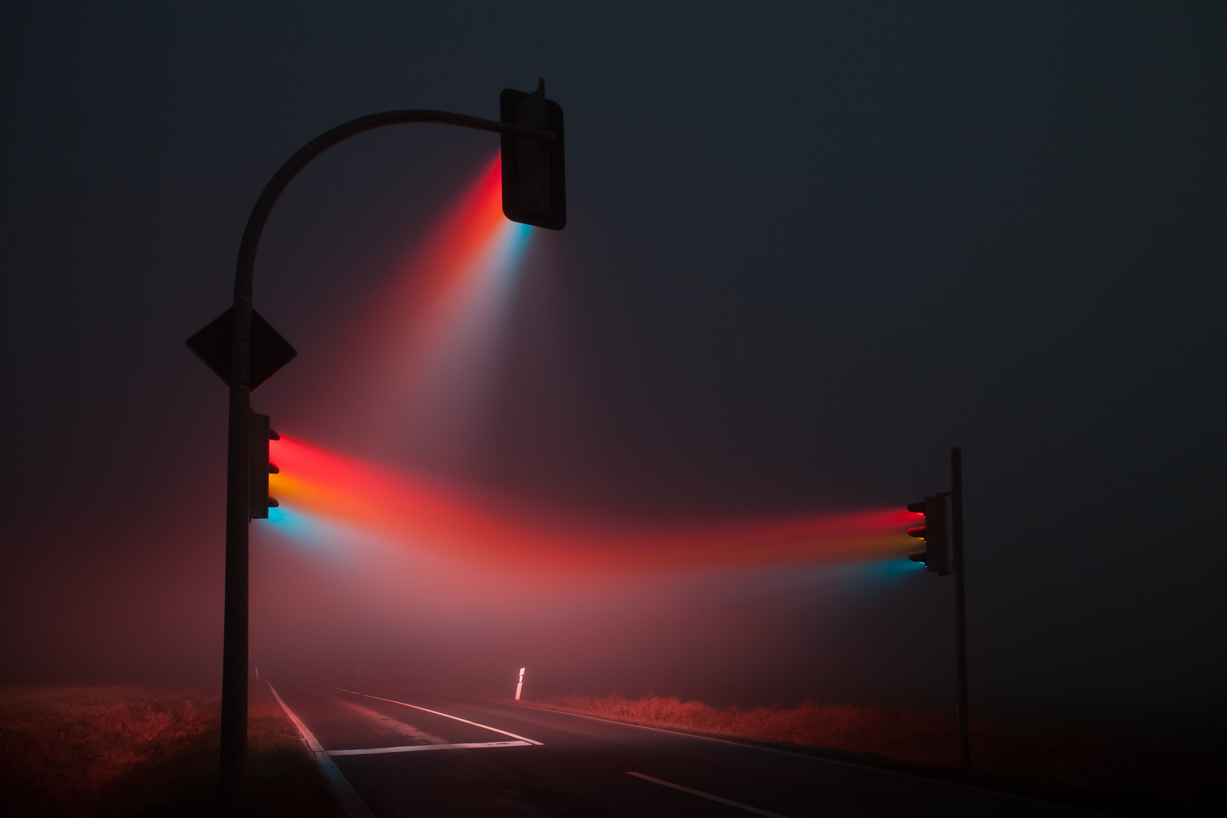 Traffic lights in mist at night on a road HD Wallpaper
