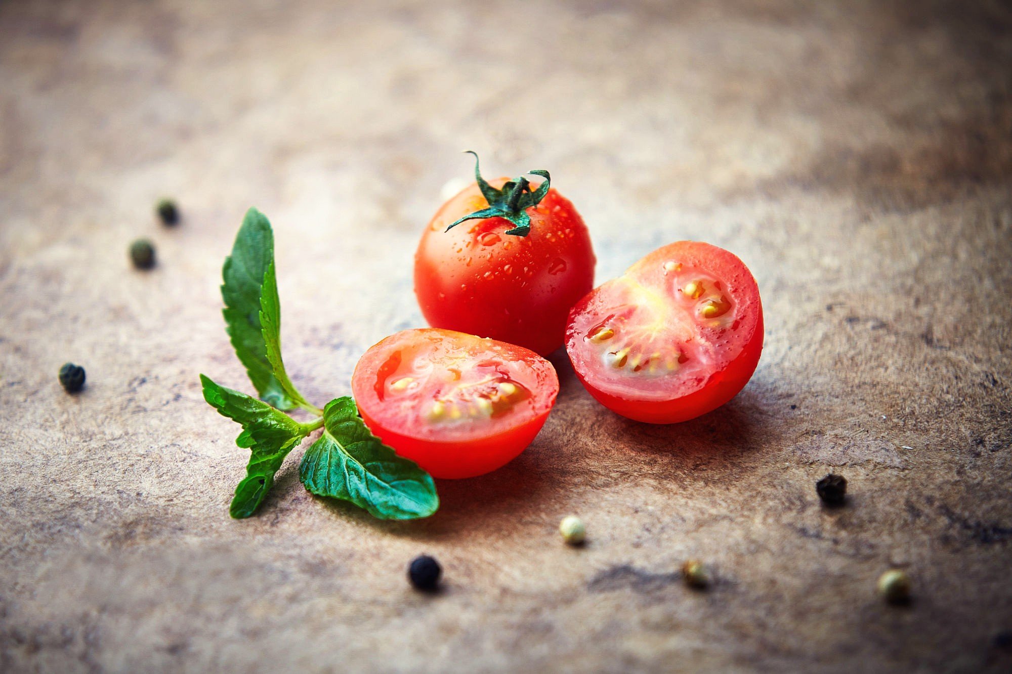 Tomatoes and mint on a textured surface HD Wallpaper