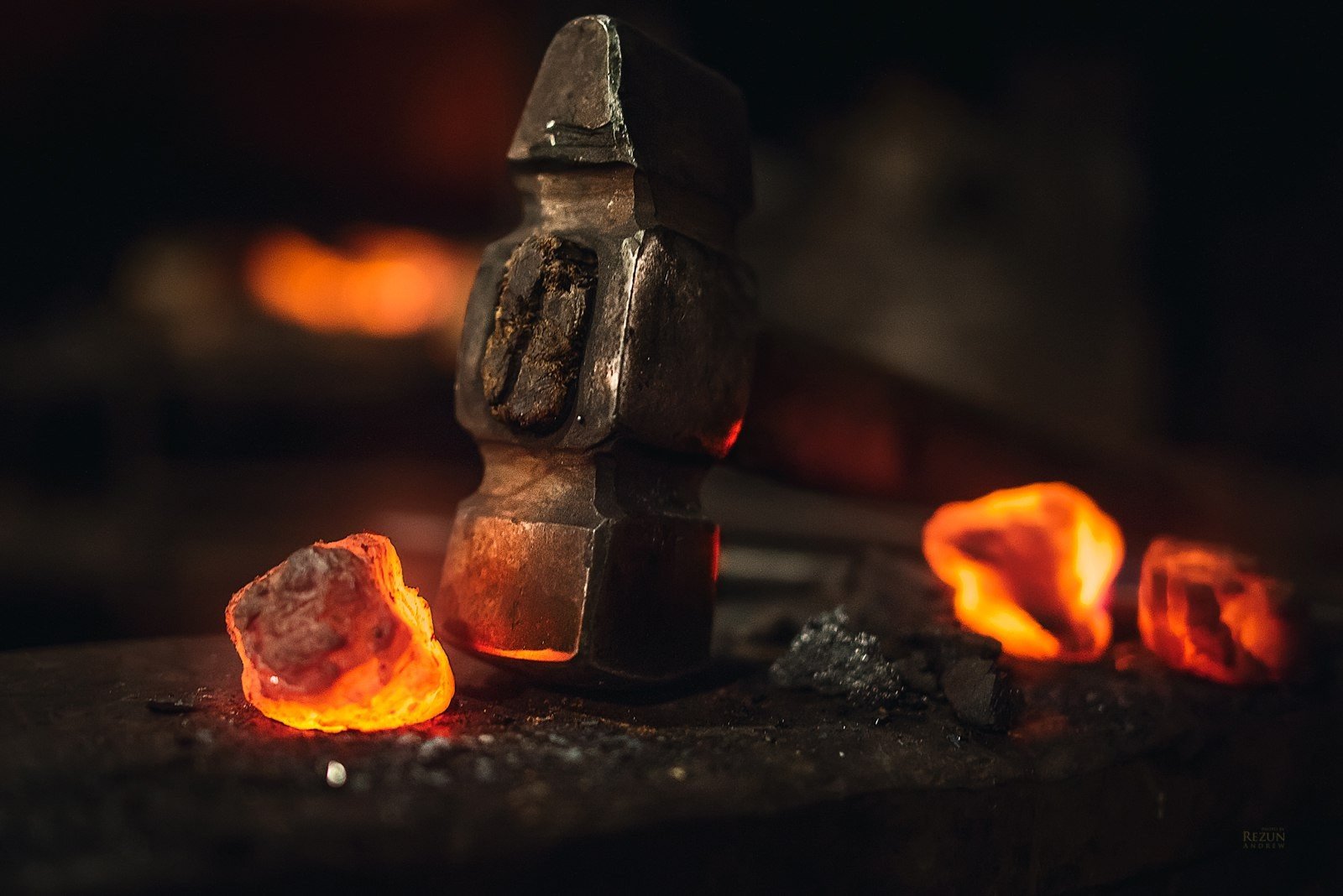 Blacksmith's hammer and glowing embers on anvil HD Wallpaper