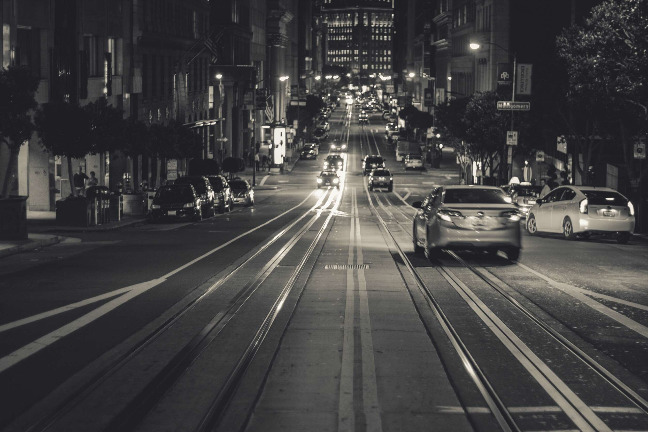 San Francisco street at night with cars and tram tracks HD Wallpaper