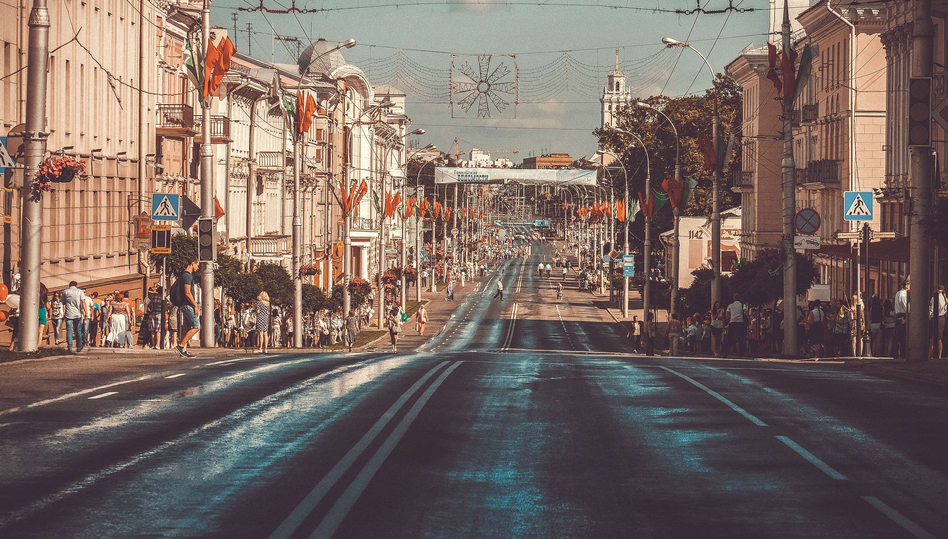 City street with flags and people HD Wallpaper
