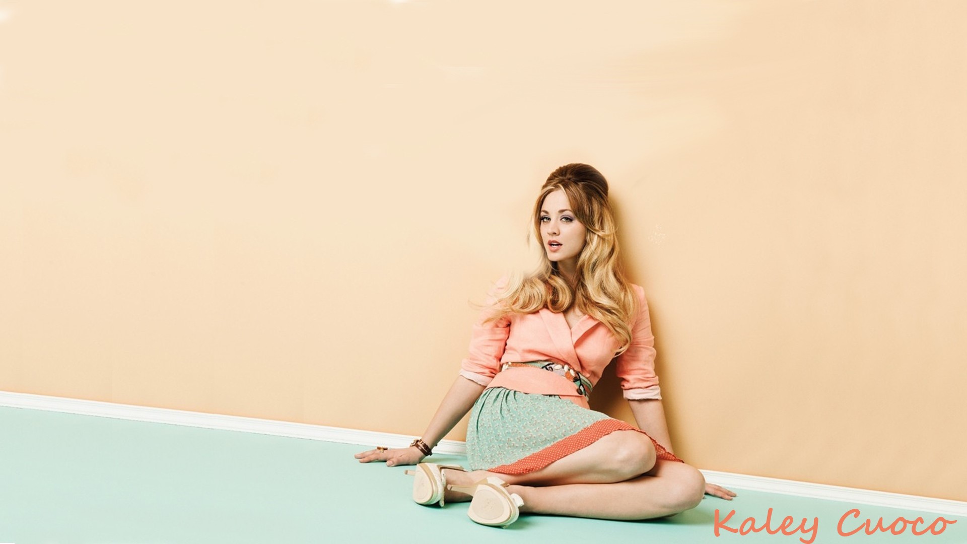 Kaley Cuoco sitting on a pastel floor HD Wallpaper