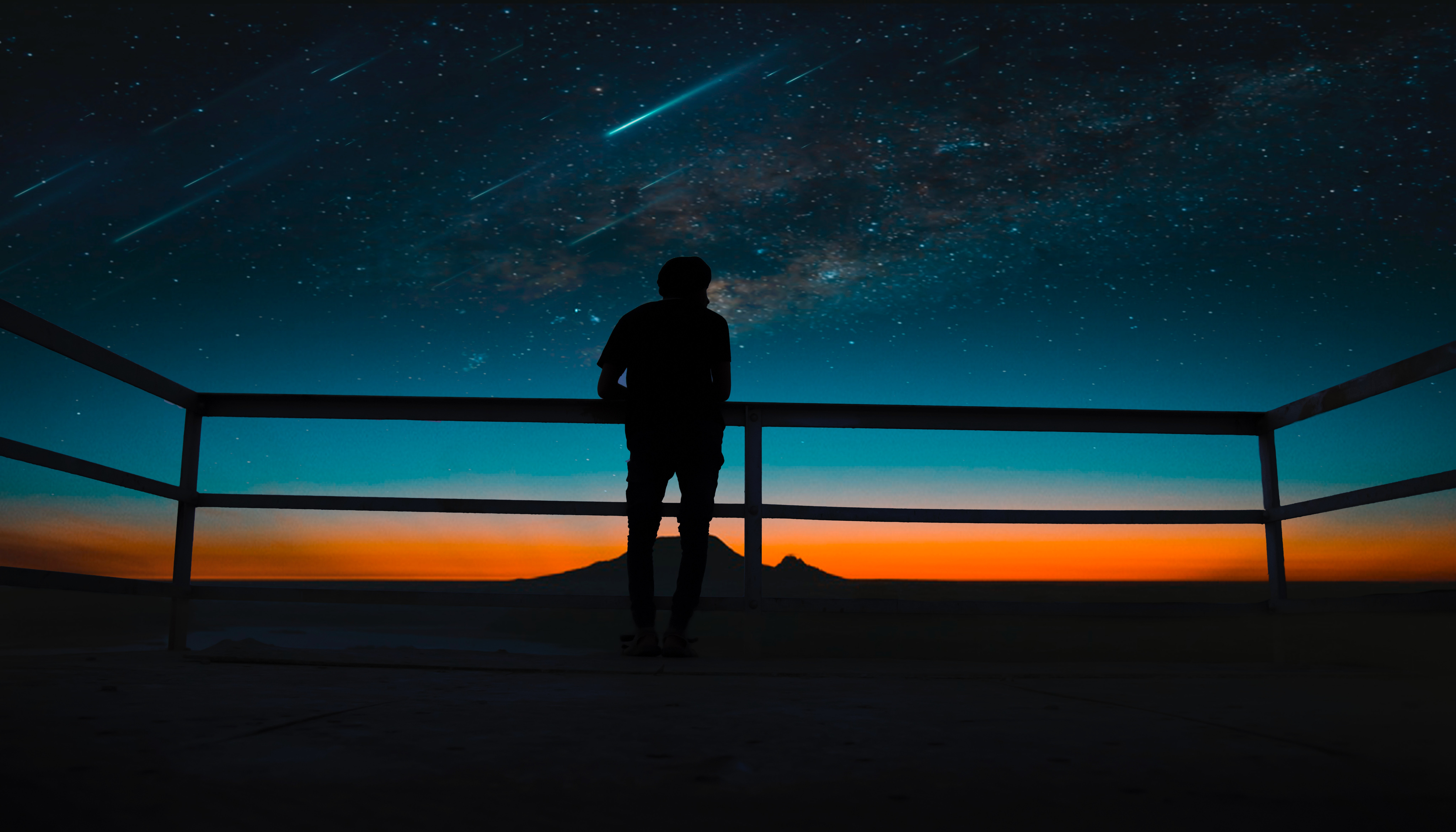 Silhouette of a person watching shooting stars at night HD Wallpaper