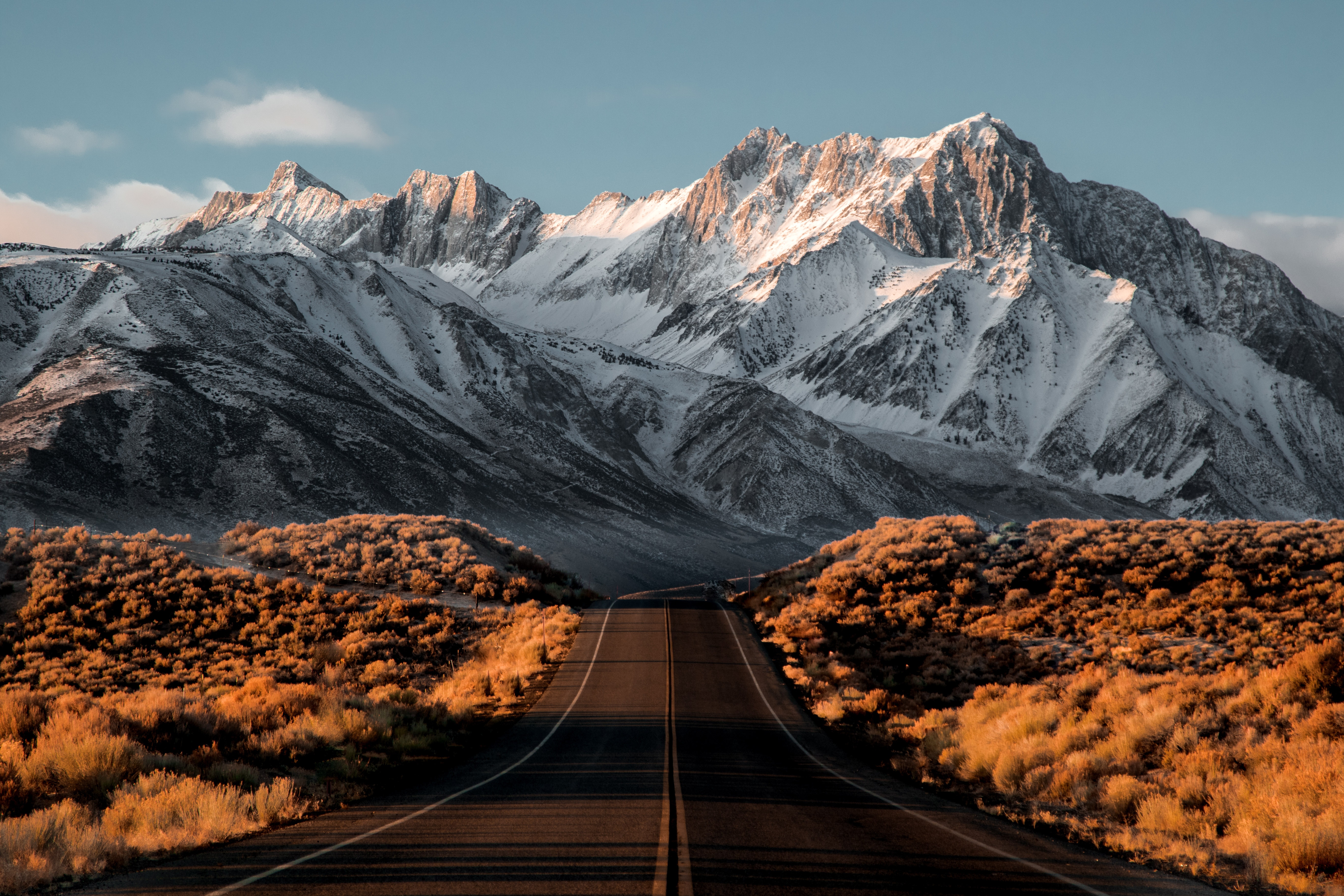 Road leading to snow-capped mountains HD Wallpaper