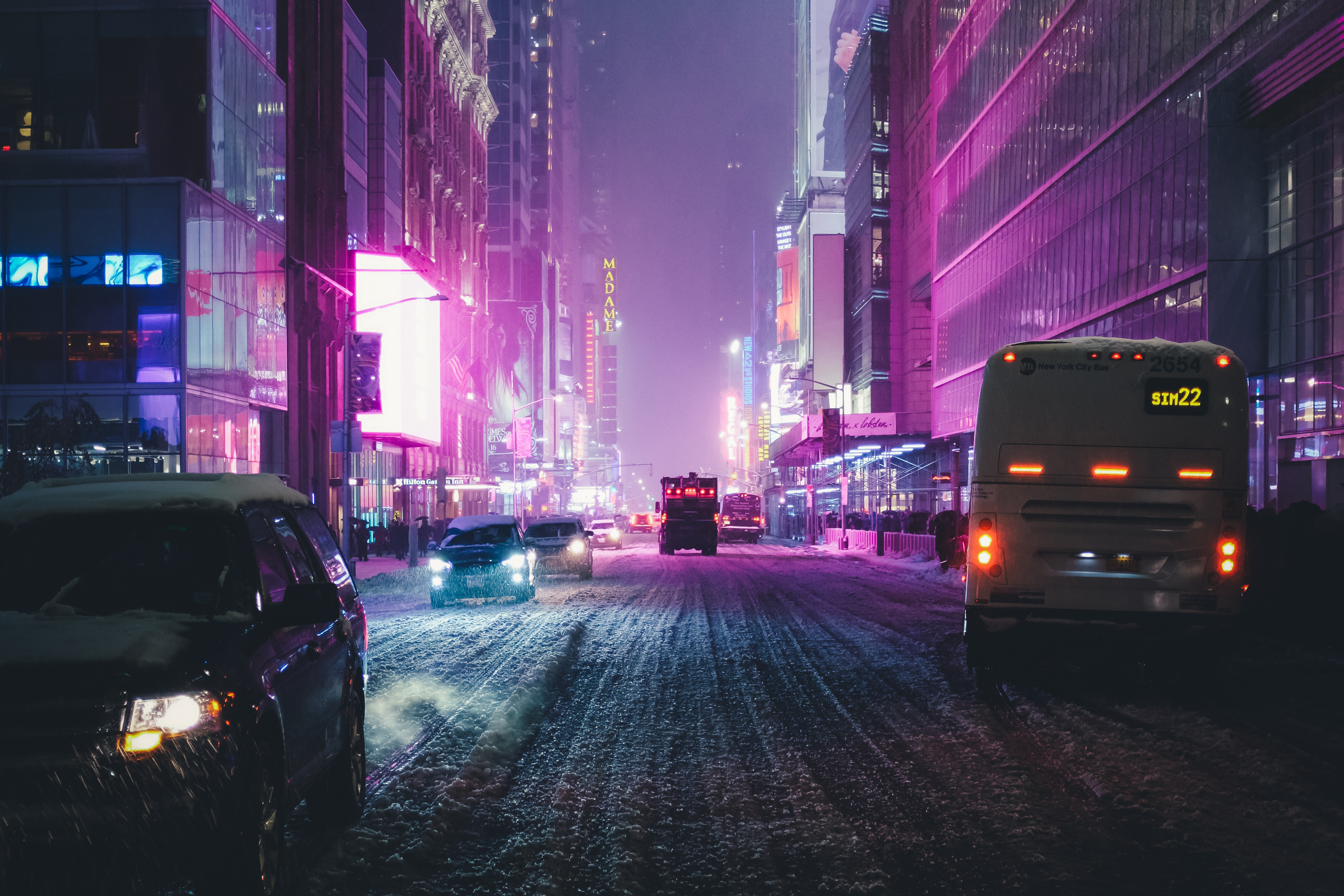 City street at night with neon lights and snow HD Wallpaper