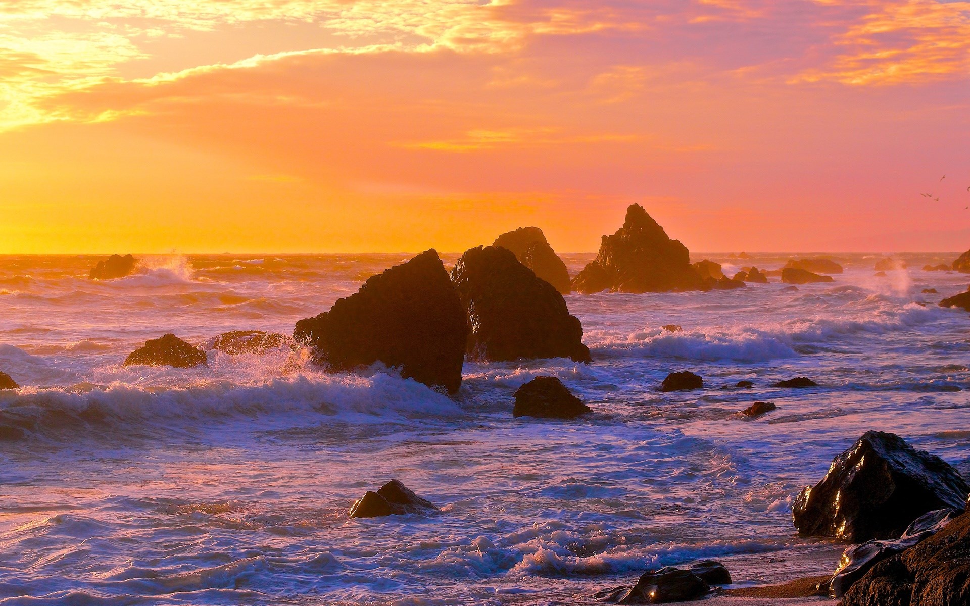 Ocean waves crash against rocks at sunset HD Wallpaper