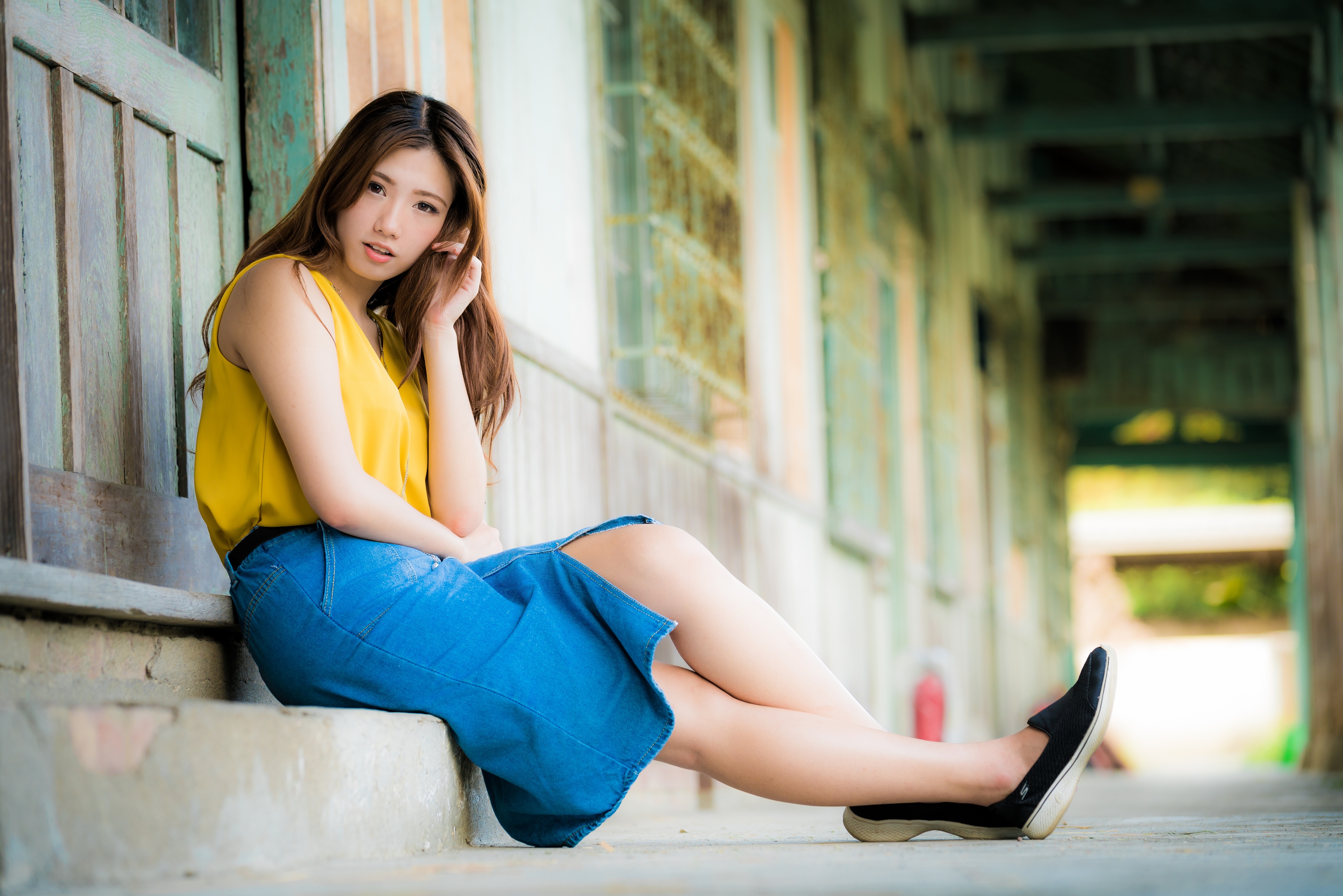 Young Asian Woman Sitting Outdoors in Casual Outfit HD Wallpaper